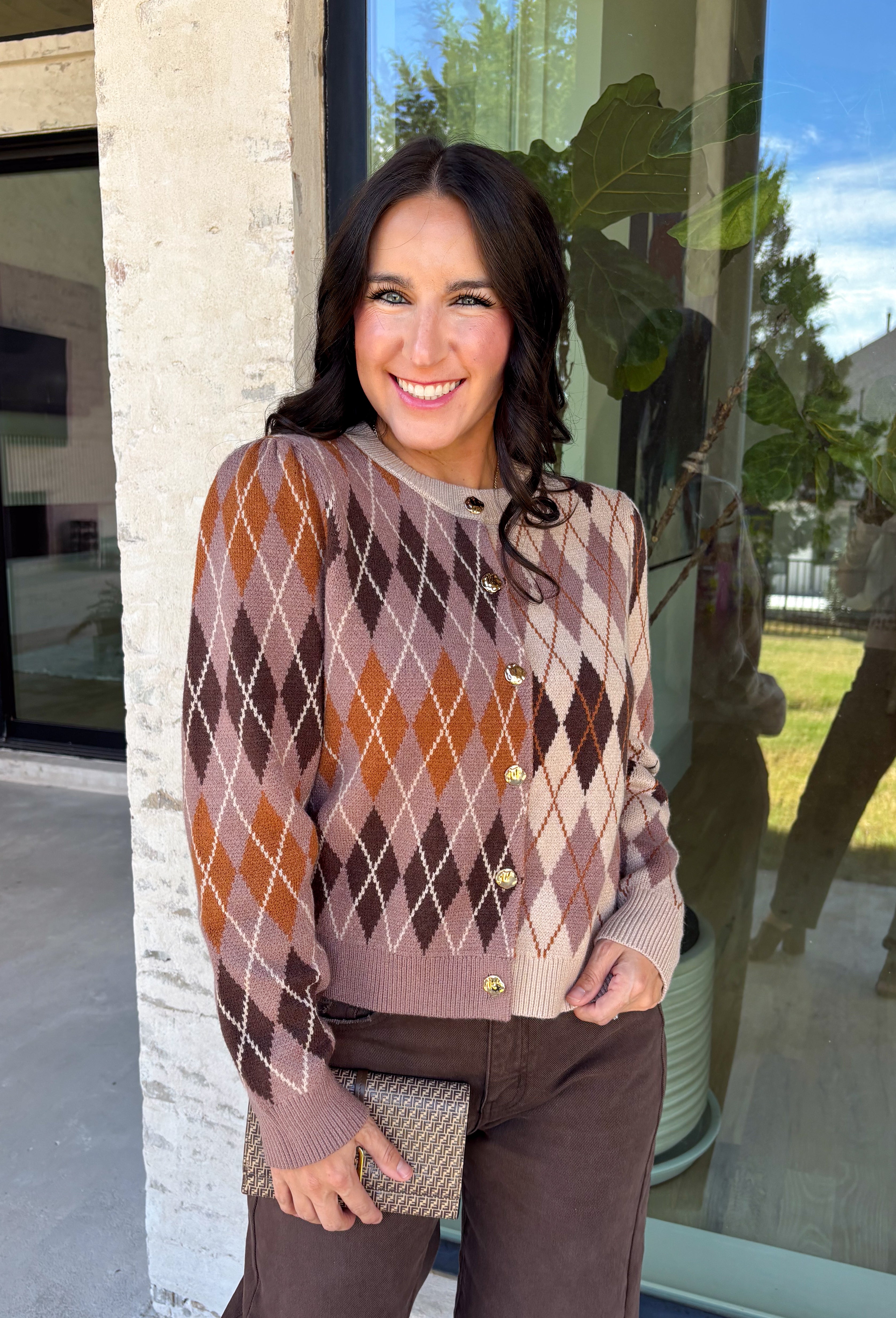 Classic patterns never go out of style, and this beautiful cardigan from THML is the perfect example. Designed with a timeless tan and brown argyle pattern, this cozy knit is finished with elegant gold buttons that add a polished touch. The neutral color palette makes it effortless to pair with everything in your wardrobe, while the ribbed neckline, cuffs, and hem create a refined finish. 