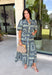 Bring effortless elegance to your wardrobe with this beautifully detailed dress from Entro. Designed with a soft light blue backdrop and an eye-catching abstract print in shades of navy, white, and cream, this timeless piece is perfect for everything from brunch dates to special gatherings. A subtle ruffle neckline adds a feminine touch, while the black buttons outlined in gold create an elevated, polished finish.