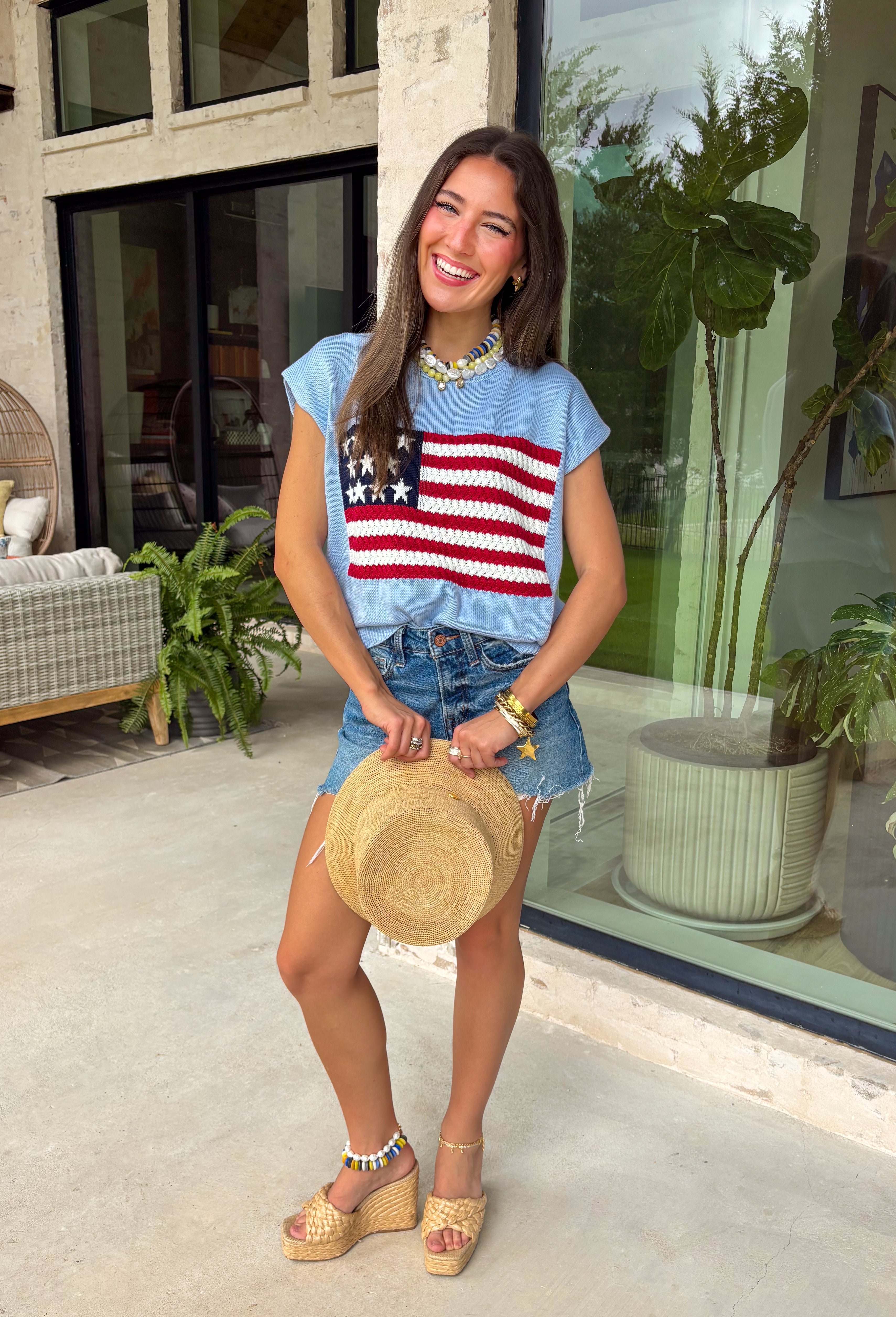 This light blue sweater top is the perfect way to celebrate summer in style! Featuring an American flag design on the front, it brings all the patriotic charm while still feeling classic and easy to wear. The lightweight knit construction makes it ideal for warm-weather celebrations, and the cap sleeves add a flattering, feminine touch. Whether you're heading to a backyard BBQ, a parade, a lake weekend, or fireworks with friends, this top is ready for all your 4th of July festivities. 