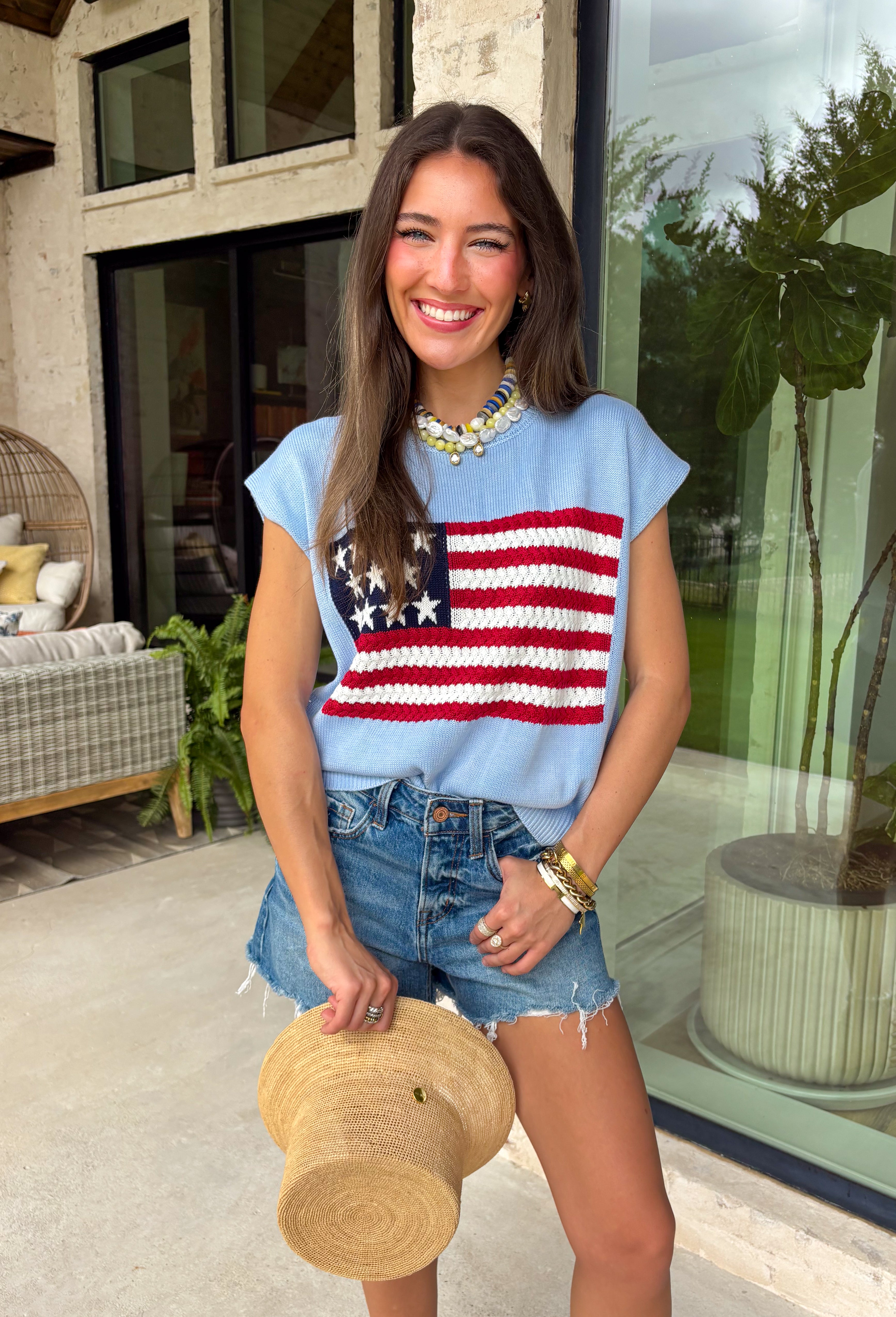 This light blue sweater top is the perfect way to celebrate summer in style! Featuring an American flag design on the front, it brings all the patriotic charm while still feeling classic and easy to wear. The lightweight knit construction makes it ideal for warm-weather celebrations, and the cap sleeves add a flattering, feminine touch. Whether you're heading to a backyard BBQ, a parade, a lake weekend, or fireworks with friends, this top is ready for all your 4th of July festivities. 