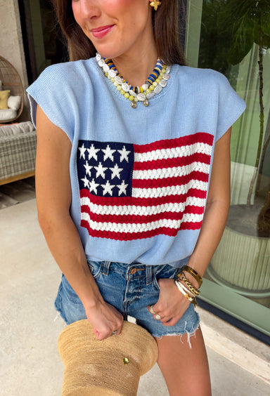 This light blue sweater top is the perfect way to celebrate summer in style! Featuring an American flag design on the front, it brings all the patriotic charm while still feeling classic and easy to wear. The lightweight knit construction makes it ideal for warm-weather celebrations, and the cap sleeves add a flattering, feminine touch. Whether you're heading to a backyard BBQ, a parade, a lake weekend, or fireworks with friends, this top is ready for all your 4th of July festivities. 