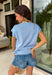 This light blue sweater top is the perfect way to celebrate summer in style! Featuring an American flag design on the front, it brings all the patriotic charm while still feeling classic and easy to wear. The lightweight knit construction makes it ideal for warm-weather celebrations, and the cap sleeves add a flattering, feminine touch. Whether you're heading to a backyard BBQ, a parade, a lake weekend, or fireworks with friends, this top is ready for all your 4th of July festivities. 