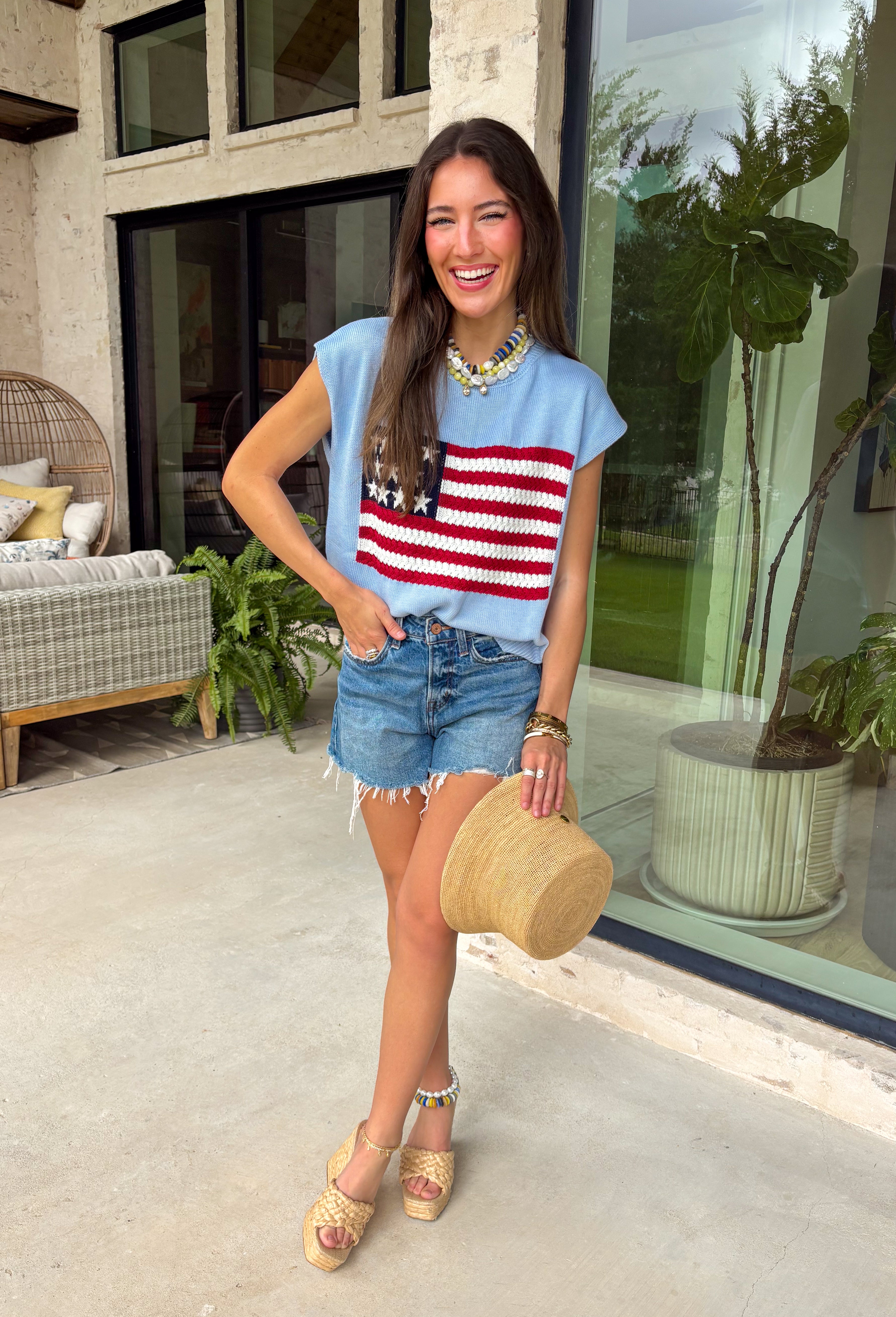 This light blue sweater top is the perfect way to celebrate summer in style! Featuring an American flag design on the front, it brings all the patriotic charm while still feeling classic and easy to wear. The lightweight knit construction makes it ideal for warm-weather celebrations, and the cap sleeves add a flattering, feminine touch. Whether you're heading to a backyard BBQ, a parade, a lake weekend, or fireworks with friends, this top is ready for all your 4th of July festivities. 