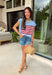 This light blue sweater top is the perfect way to celebrate summer in style! Featuring an American flag design on the front, it brings all the patriotic charm while still feeling classic and easy to wear. The lightweight knit construction makes it ideal for warm-weather celebrations, and the cap sleeves add a flattering, feminine touch. Whether you're heading to a backyard BBQ, a parade, a lake weekend, or fireworks with friends, this top is ready for all your 4th of July festivities. 