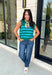 Classic stripes get a bold fall refresh with this cozy sleeveless sweater! Featuring a rich pine green knit with vibrant blue stripes, this sleeveless top is an easy way to add color to your seasonal wardrobe. Functional gold button closures along the sides add a unique, elevated touch, while the ribbed crew neckline and hem give it a timeless finish.