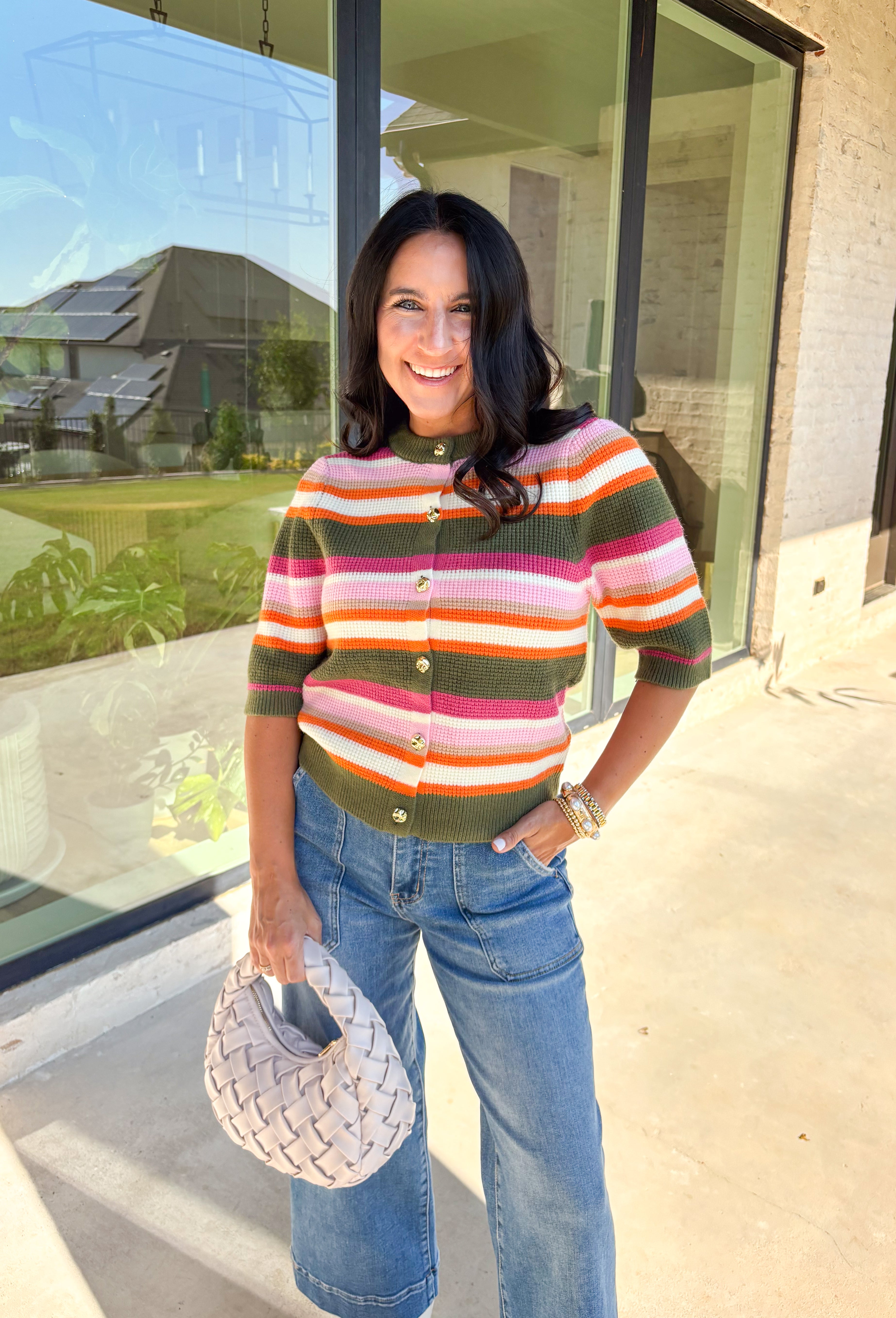 Add a playful pop to your fall wardrobe with this colorful knit cardigan. Designed in olive, shades of pink, white, tan, and orange, it’s a vibrant piece that feels both cozy and chic. The short sleeves make it easy to layer, while hammered gold buttons down the front add a polished finish. With its mix of warm tones and soft knit, this cardigan is a versatile piece you’ll find yourself reaching for all season long.
