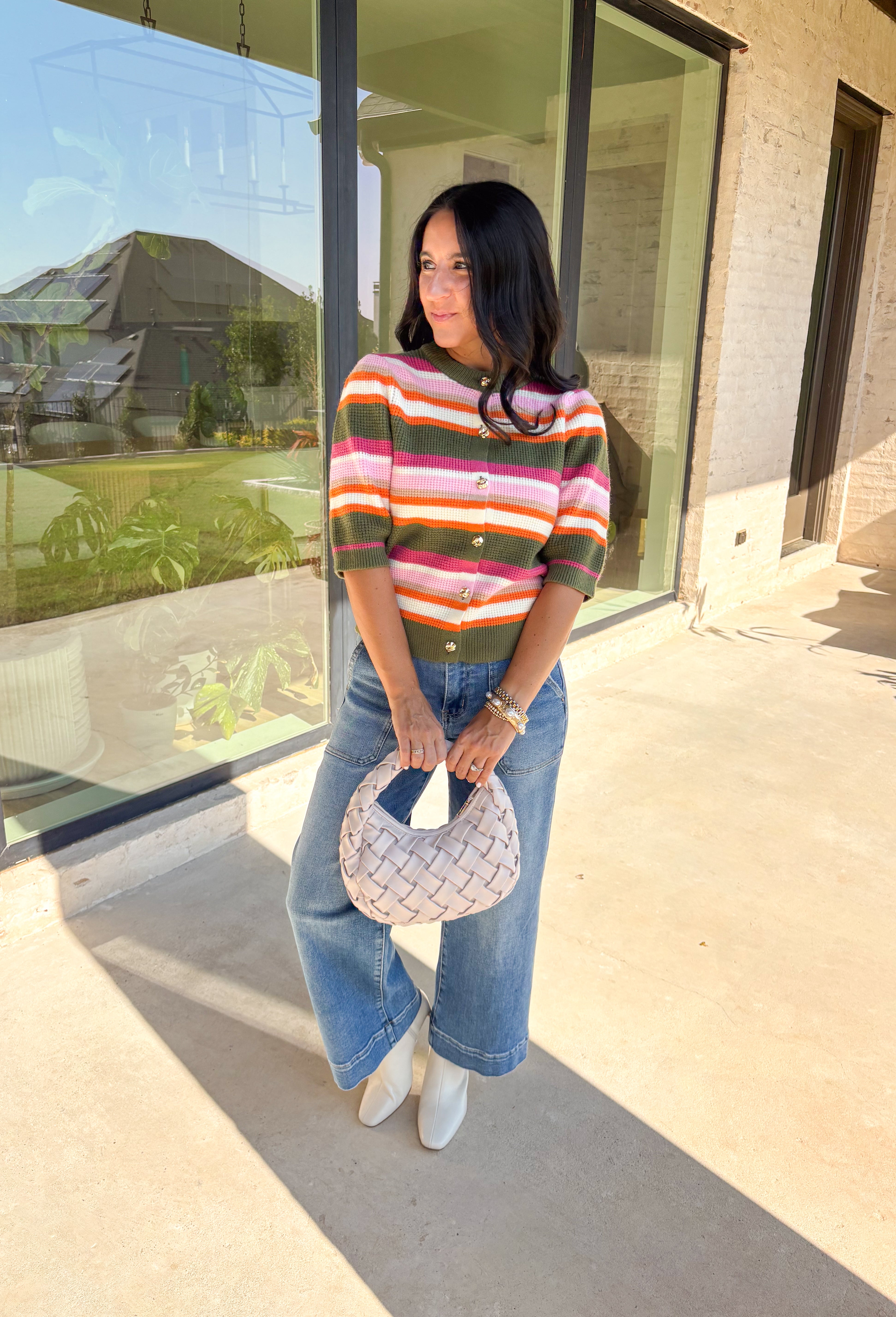 Add a playful pop to your fall wardrobe with this colorful knit cardigan. Designed in olive, shades of pink, white, tan, and orange, it’s a vibrant piece that feels both cozy and chic. The short sleeves make it easy to layer, while hammered gold buttons down the front add a polished finish. With its mix of warm tones and soft knit, this cardigan is a versatile piece you’ll find yourself reaching for all season long.