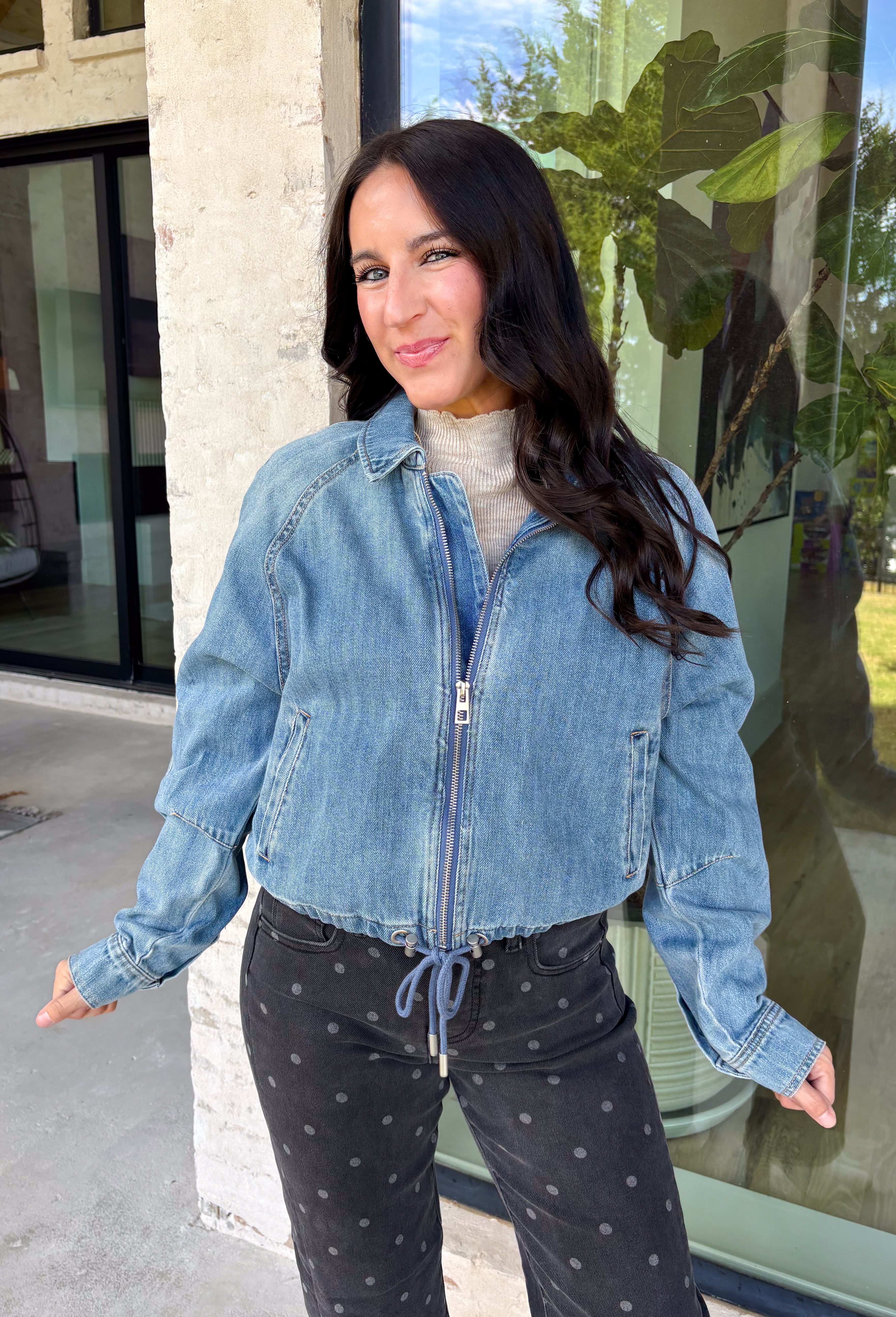 A classic denim layer gets a fresh update with this medium wash jacket from Risen. The timeless wash makes it easy to throw on with everything from fall dresses to cozy knits, while the front zipper closure gives it a more modern feel than your traditional button-front denim jacket. A collared neckline keeps the look classic, and button cuffs add a familiar denim detail at the sleeves. The adjustable toggle drawstring hem lets you customize the shape, while side pockets add everyday function.