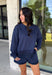 Cozy gets a pretty little upgrade with this navy sweatshirt from Sunday Edition. The classic long sleeve silhouette is finished with a lace hem, adding a feminine touch to an otherwise casual favorite. A soft fleece lining keeps it extra comfortable as chilly fall days start turning into winter weather. Pair it with the matching shorts for a cute coordinated set that’s perfect for relaxing, traveling, or casual weekend plans, or mix it into your closet with denim for an easy everyday outfit. 