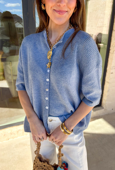 Soft, sweet, and perfect for spring layering, this light blue ribbed button-down knit short sleeve sweater by Things Between is an easy everyday favorite. The ribbed texture gives it a flattering fit, while the button-down front adds a classic touch you can wear closed as a top or slightly open over a tank for a more relaxed vibe. Lightweight with a cozy feel, this piece is perfect for those breezy spring mornings and cool evenings when you still want something cute and comfortable.