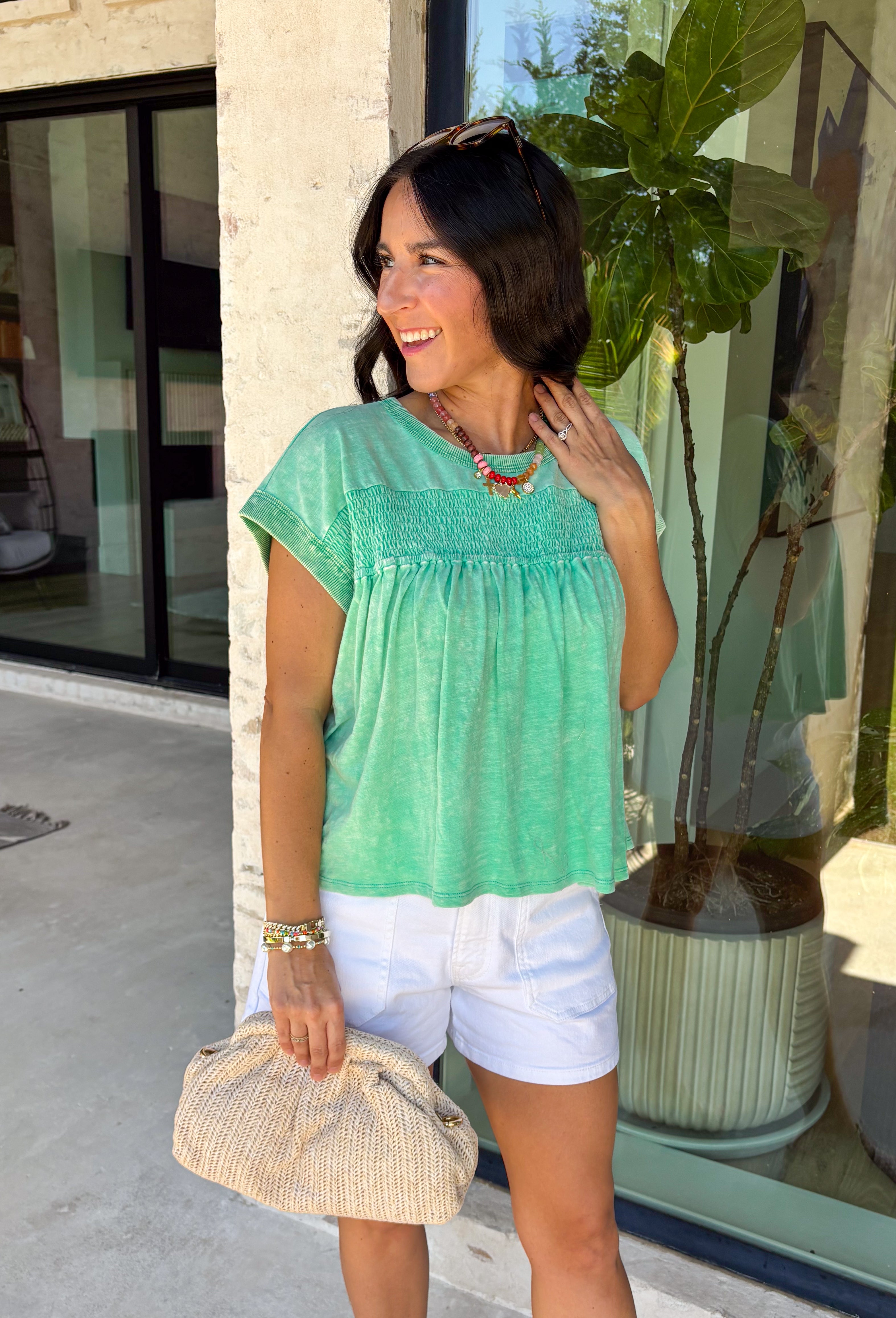 This green short sleeve top is the kind of easy, go-to piece you’ll reach for all summer long! The smocking detail across the front adds just the right amount of texture while creating a flattering, comfortable fit. Made from breathable 100% cotton, it’s lightweight and perfect for staying cool on warm days. It’s simple, versatile, and effortlessly put together—exactly what you want for busy days on the go. Pair it with denim shorts, white jeans, or a skirt for an easy everyday look. 
