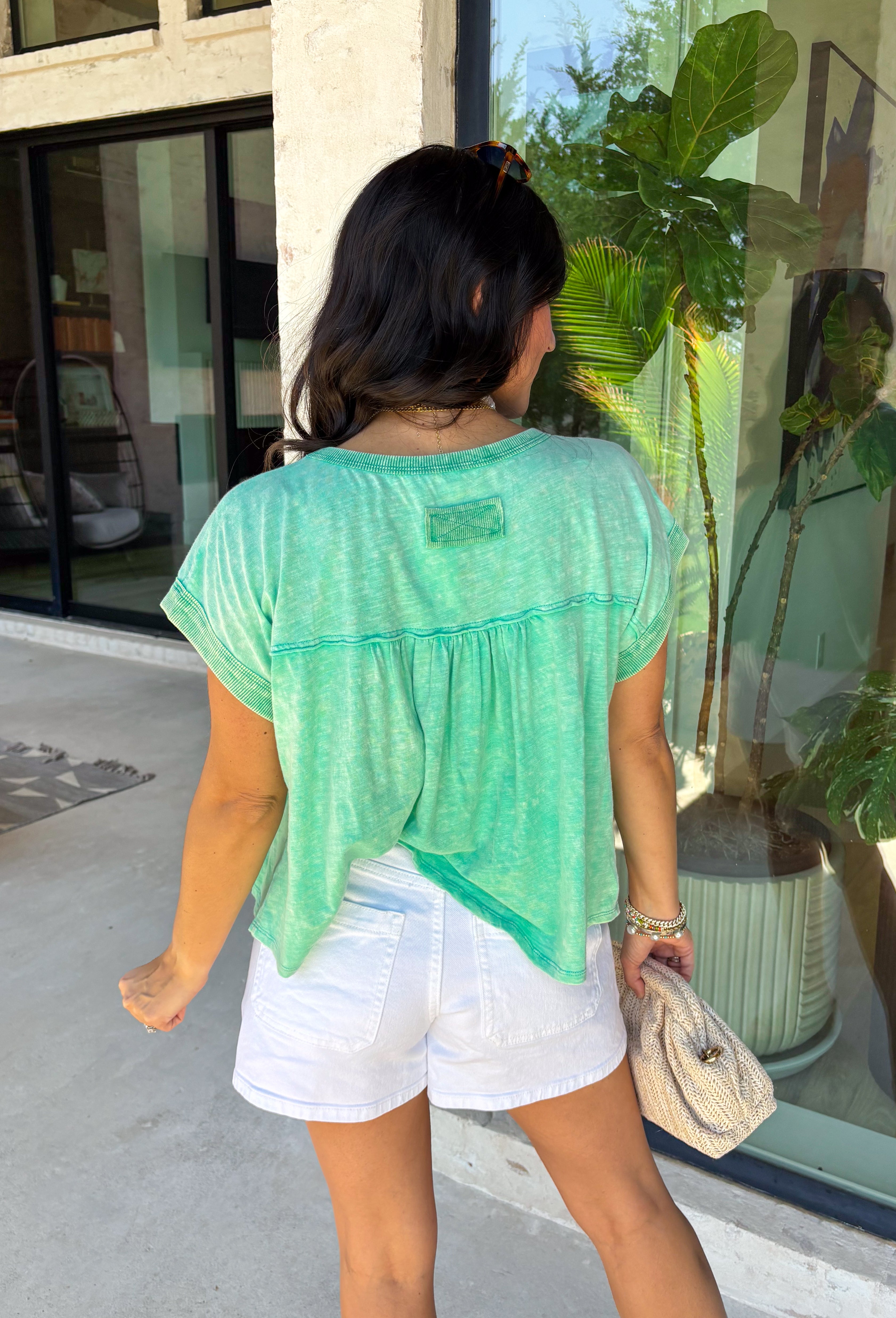 This green short sleeve top is the kind of easy, go-to piece you’ll reach for all summer long! The smocking detail across the front adds just the right amount of texture while creating a flattering, comfortable fit. Made from breathable 100% cotton, it’s lightweight and perfect for staying cool on warm days. It’s simple, versatile, and effortlessly put together—exactly what you want for busy days on the go. Pair it with denim shorts, white jeans, or a skirt for an easy everyday look. 