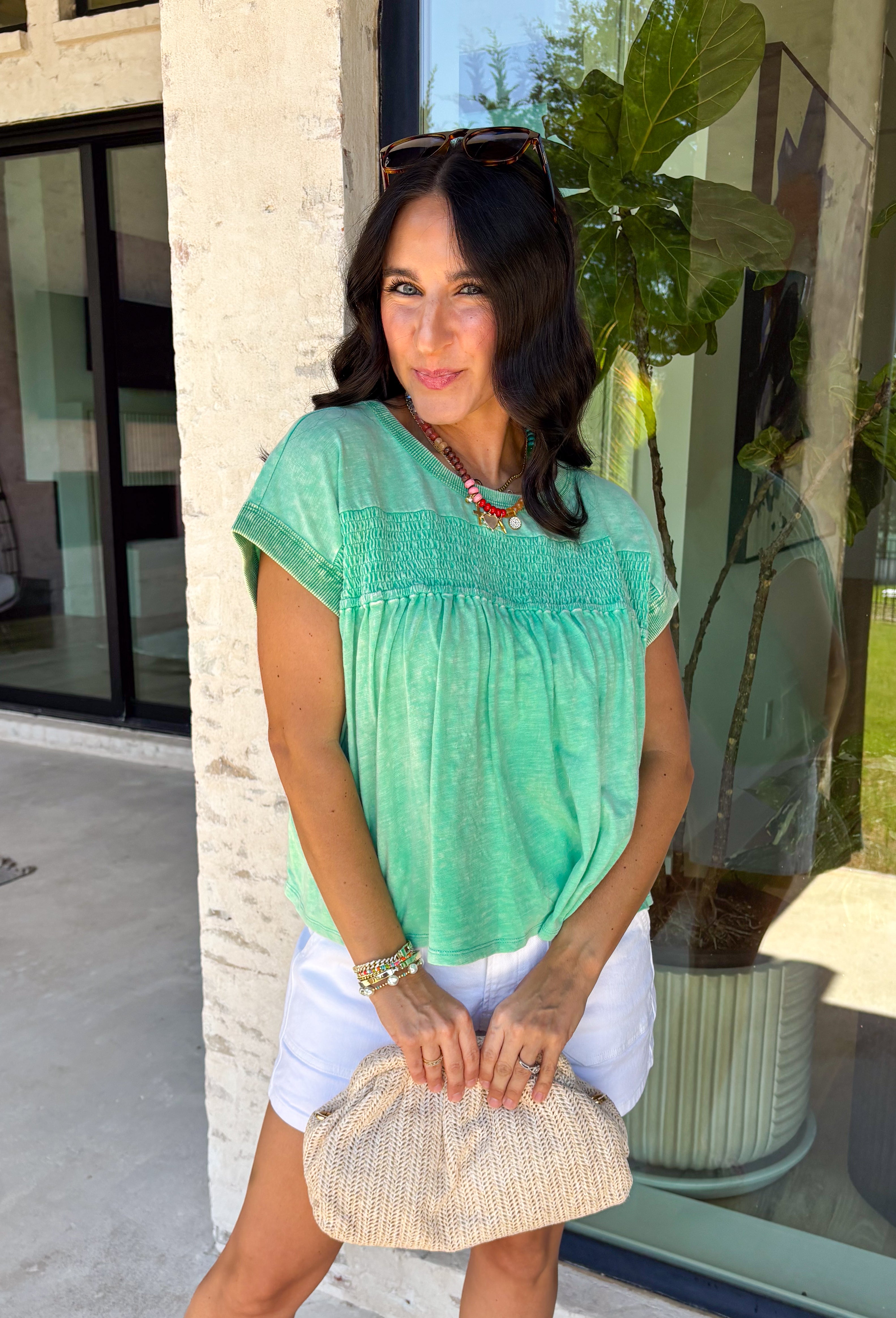 This green short sleeve top is the kind of easy, go-to piece you’ll reach for all summer long! The smocking detail across the front adds just the right amount of texture while creating a flattering, comfortable fit. Made from breathable 100% cotton, it’s lightweight and perfect for staying cool on warm days. It’s simple, versatile, and effortlessly put together—exactly what you want for busy days on the go. Pair it with denim shorts, white jeans, or a skirt for an easy everyday look. 