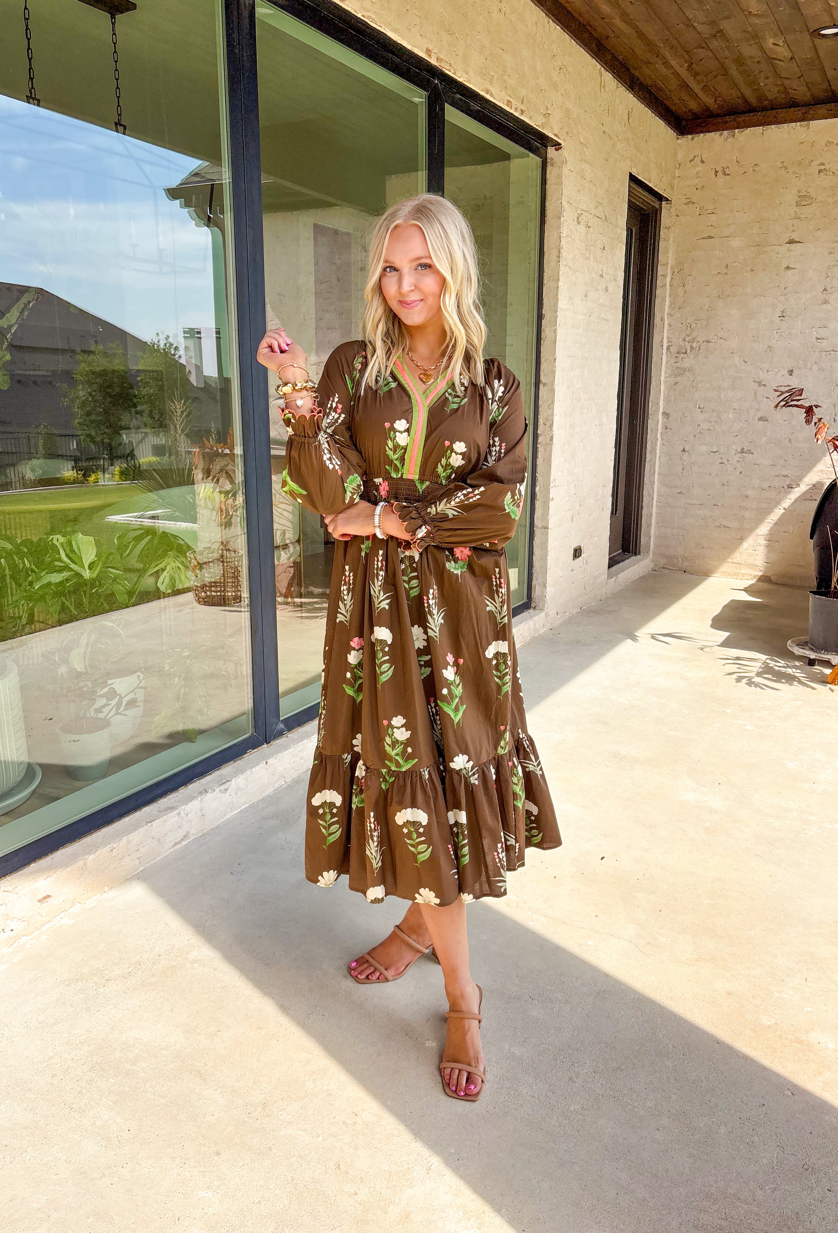 This brown floral midi dress is everything we love about fall—rich tones, effortless comfort, and just the right amount of charm. Designed with a flattering elastic waist and scalloped sleeve detail, this long sleeve beauty features a neutral floral print with pops of olive, cream, and coral. The olive and coral trim along the neckline and along the front add a pop of contrast that pulls it all together. It's the kind of dress you'll reach for on repeat this season!