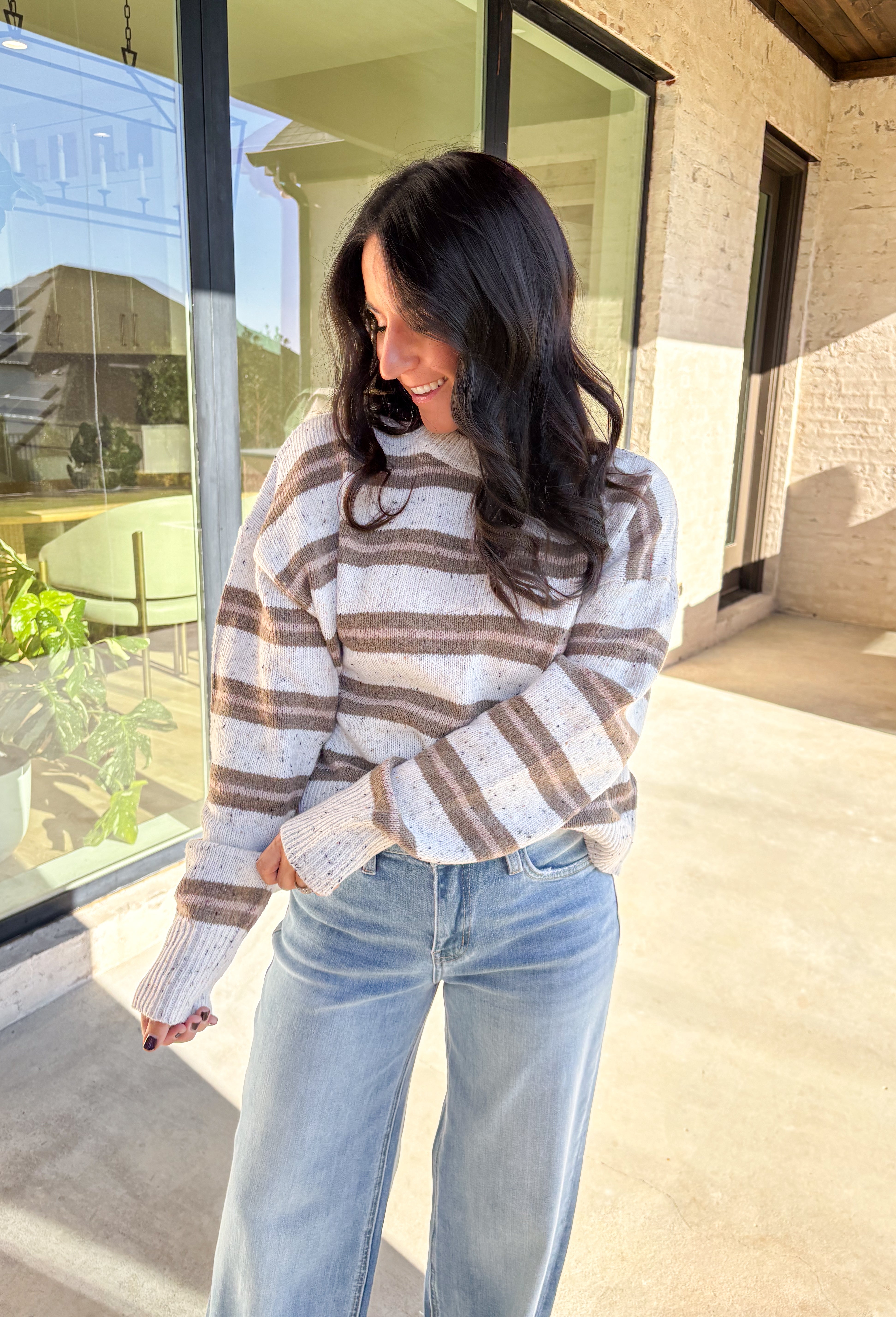 This neutral striped sweater by Double Zero brings effortless comfort and style to your fall wardrobe. Featuring a flecked knit texture with brown stripes throughout, this mock neck pullover is as cozy as it is chic. The soft, medium-weight knit makes it perfect for layering or wearing solo on those crisp autumn days.