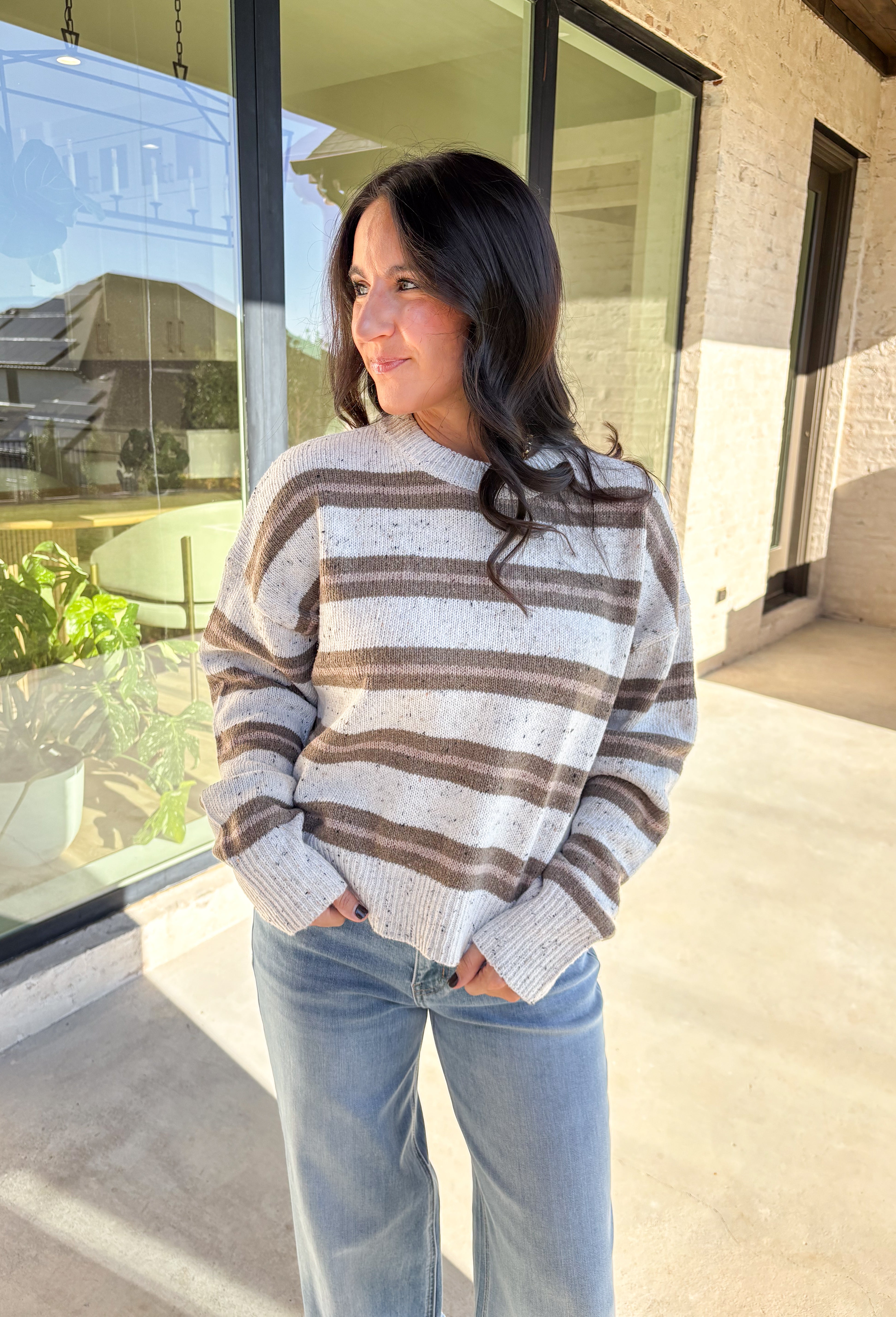 This neutral striped sweater by Double Zero brings effortless comfort and style to your fall wardrobe. Featuring a flecked knit texture with brown stripes throughout, this mock neck pullover is as cozy as it is chic. The soft, medium-weight knit makes it perfect for layering or wearing solo on those crisp autumn days.