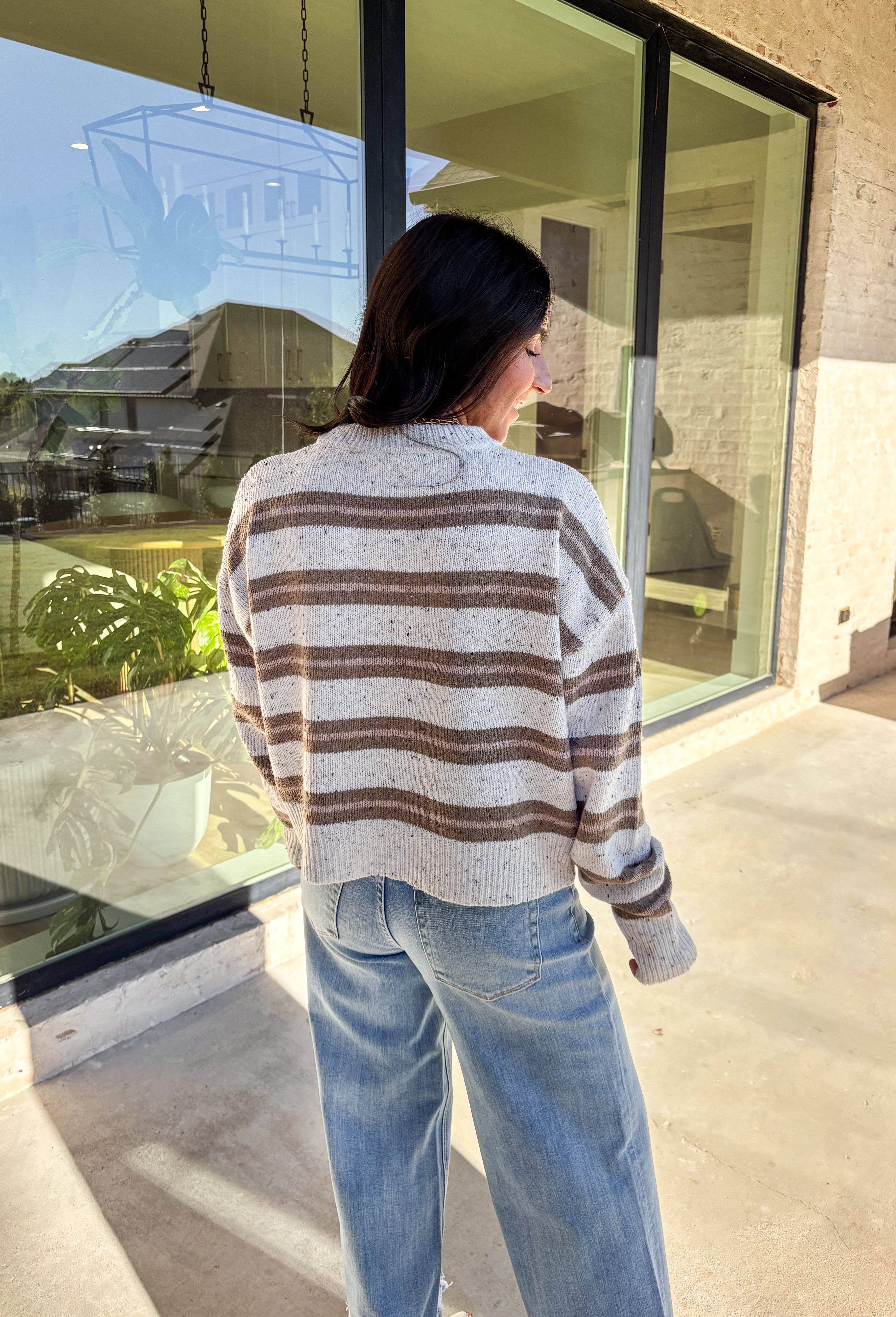 This neutral striped sweater by Double Zero brings effortless comfort and style to your fall wardrobe. Featuring a flecked knit texture with brown stripes throughout, this mock neck pullover is as cozy as it is chic. The soft, medium-weight knit makes it perfect for layering or wearing solo on those crisp autumn days.