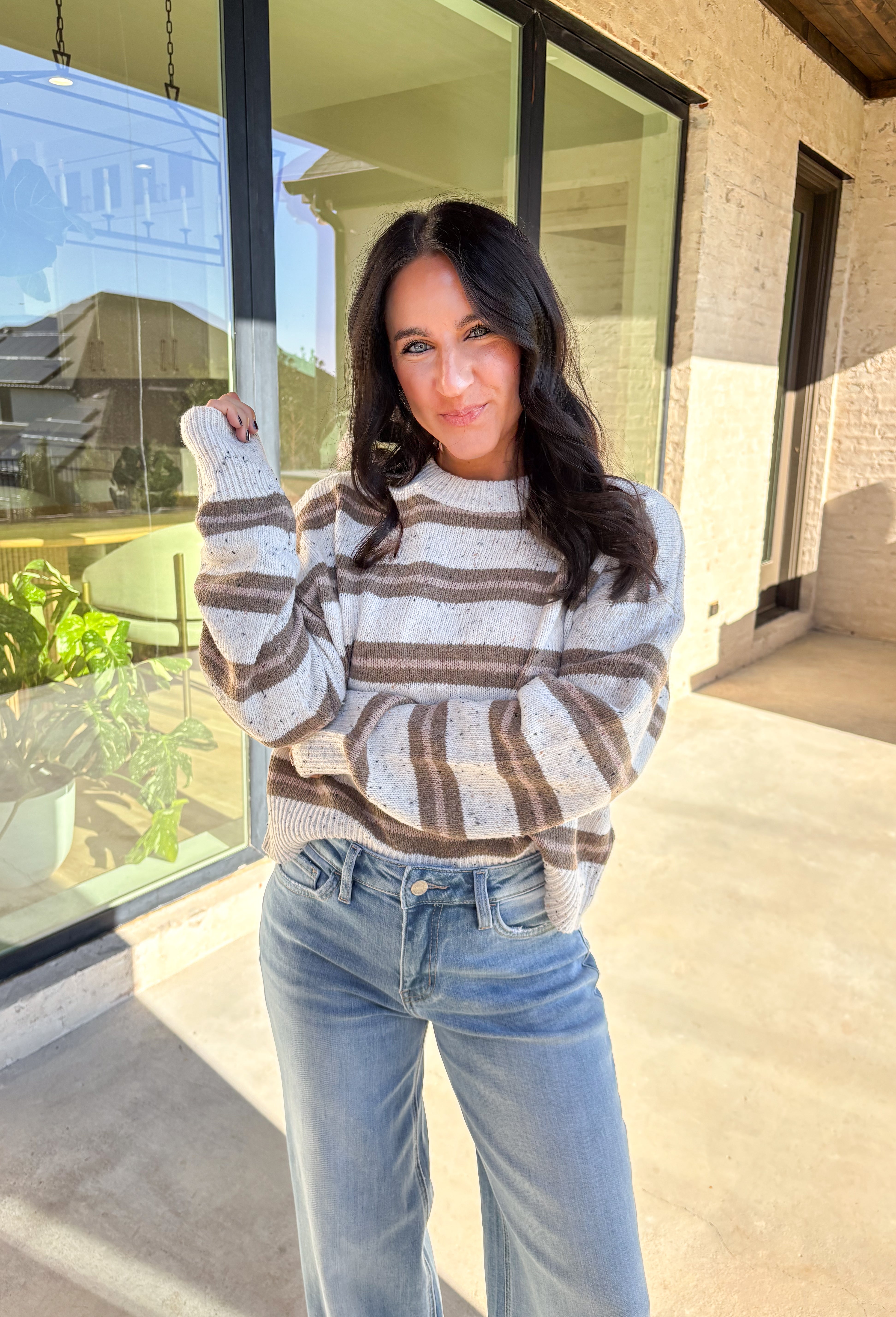 This neutral striped sweater by Double Zero brings effortless comfort and style to your fall wardrobe. Featuring a flecked knit texture with brown stripes throughout, this mock neck pullover is as cozy as it is chic. The soft, medium-weight knit makes it perfect for layering or wearing solo on those crisp autumn days.