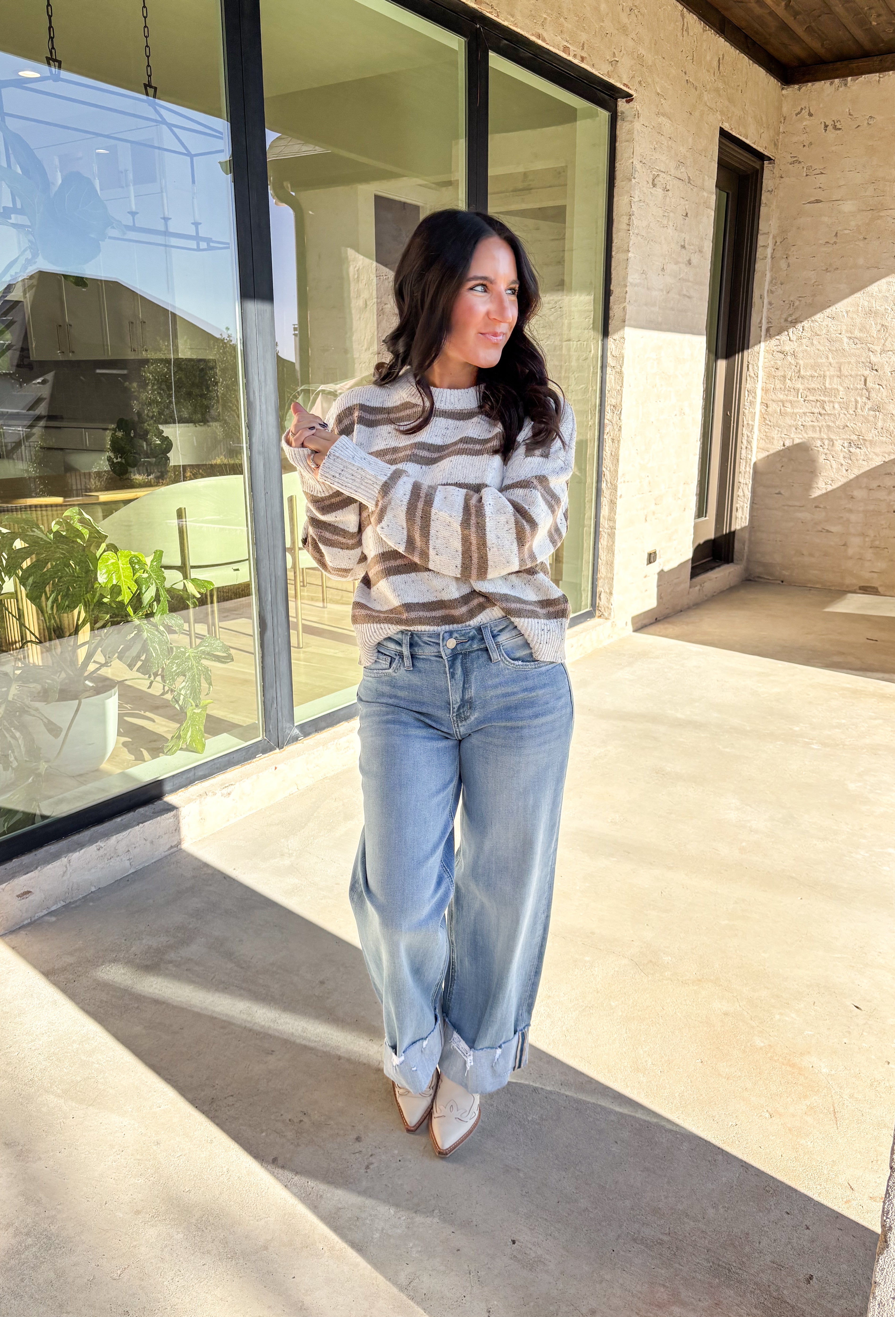 This neutral striped sweater by Double Zero brings effortless comfort and style to your fall wardrobe. Featuring a flecked knit texture with brown stripes throughout, this mock neck pullover is as cozy as it is chic. The soft, medium-weight knit makes it perfect for layering or wearing solo on those crisp autumn days.