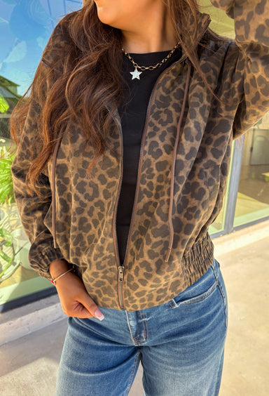 Bring the wild side to your fall layering with this leopard zip-up jacket! The ruffle neckline and tie-front detail add a playful twist to a classic print, while the elastic cuffs and hem keep it comfy and flattering. Toss it over your favorite tee and jeans for an effortless outfit that still makes a statement.