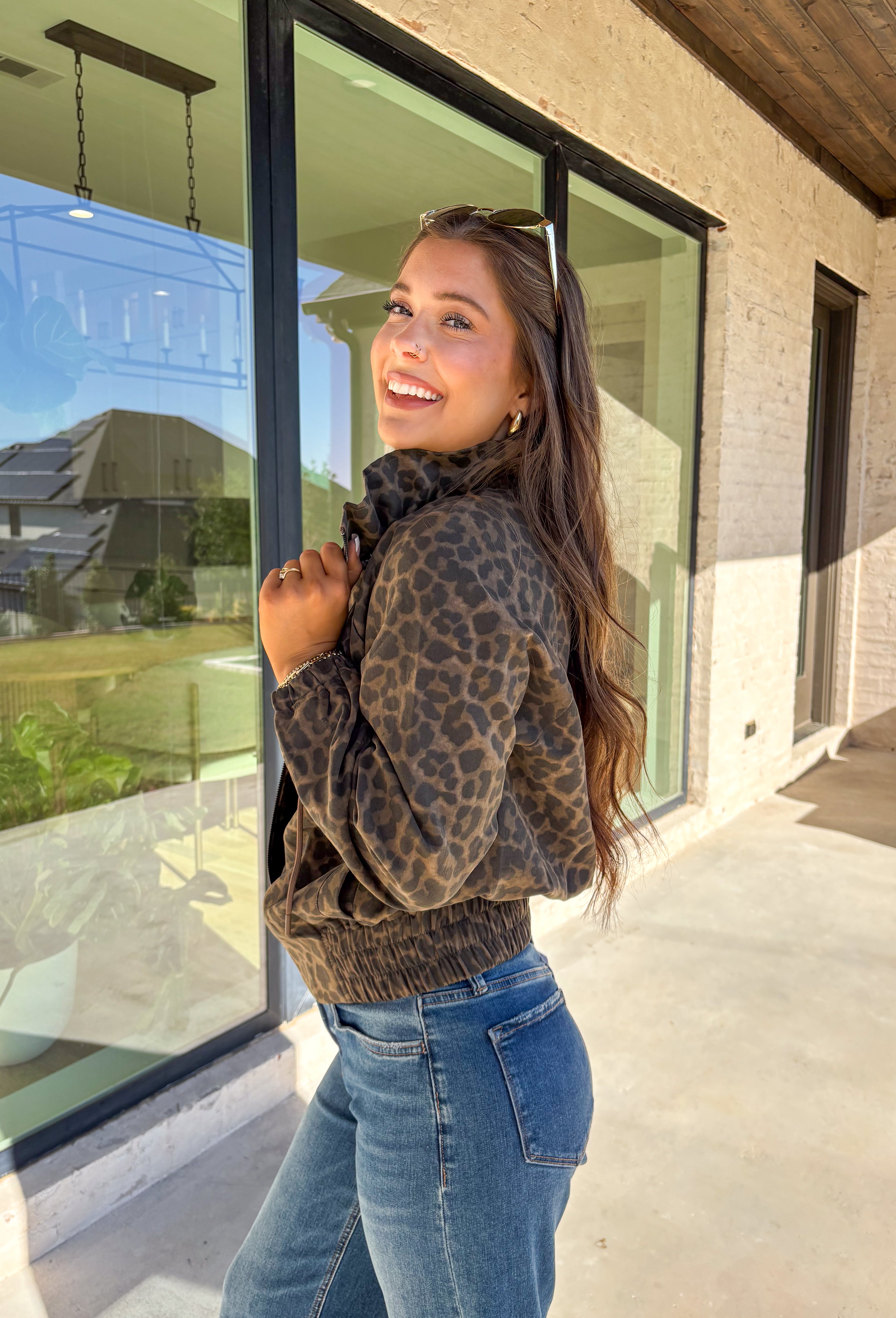 Bring the wild side to your fall layering with this leopard zip-up jacket! The ruffle neckline and tie-front detail add a playful twist to a classic print, while the elastic cuffs and hem keep it comfy and flattering. Toss it over your favorite tee and jeans for an effortless outfit that still makes a statement.