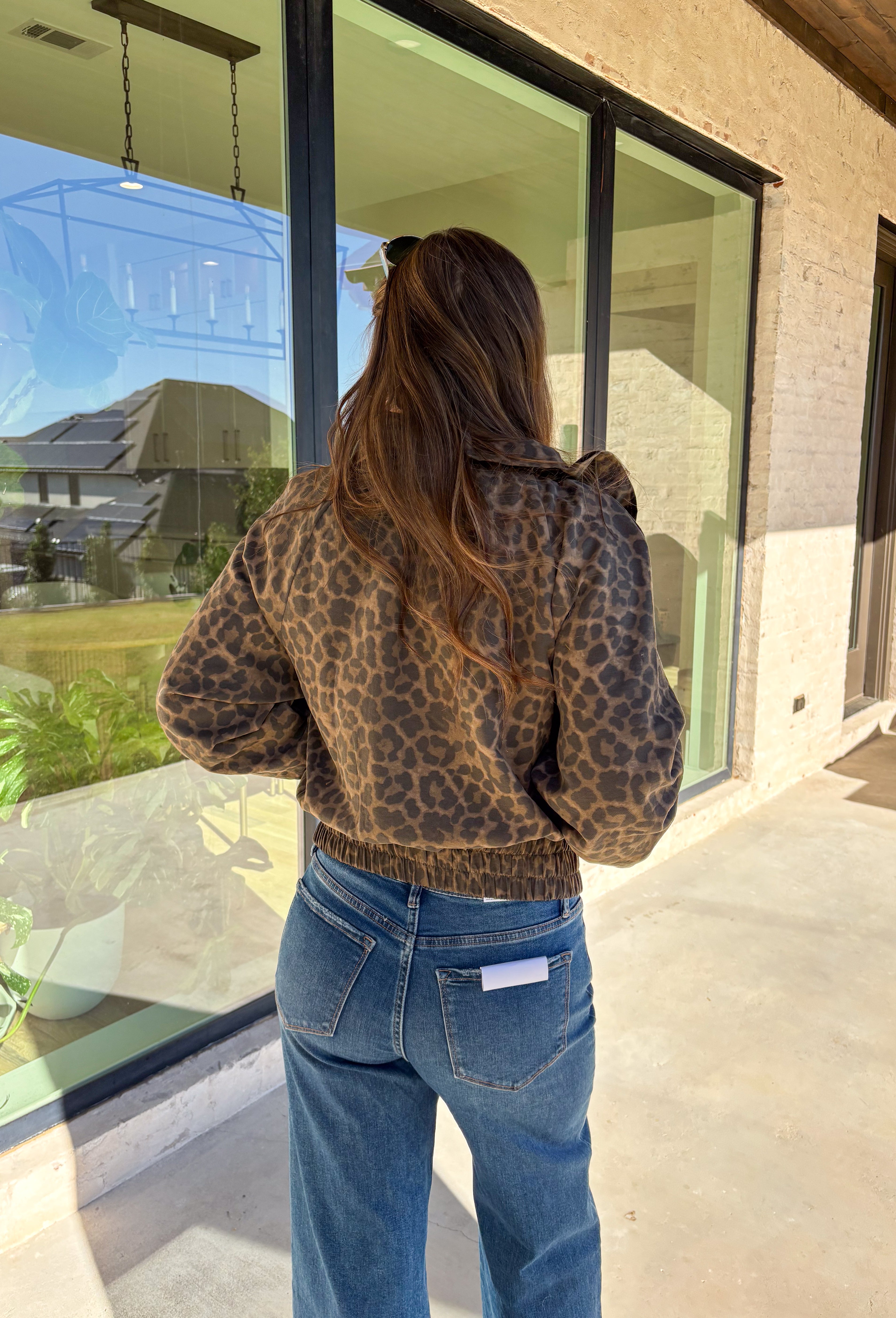Bring the wild side to your fall layering with this leopard zip-up jacket! The ruffle neckline and tie-front detail add a playful twist to a classic print, while the elastic cuffs and hem keep it comfy and flattering. Toss it over your favorite tee and jeans for an effortless outfit that still makes a statement.