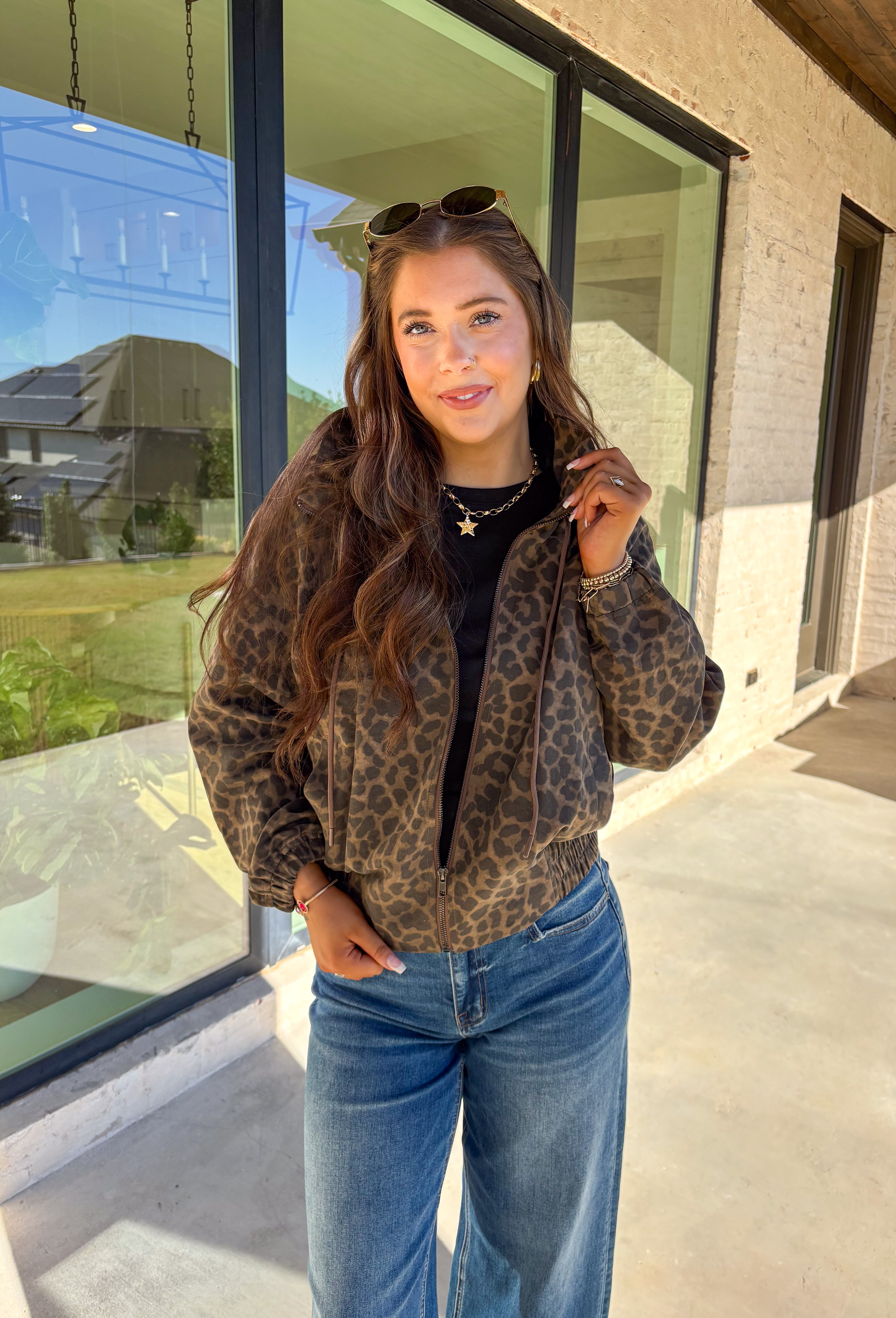 Bring the wild side to your fall layering with this leopard zip-up jacket! The ruffle neckline and tie-front detail add a playful twist to a classic print, while the elastic cuffs and hem keep it comfy and flattering. Toss it over your favorite tee and jeans for an effortless outfit that still makes a statement.