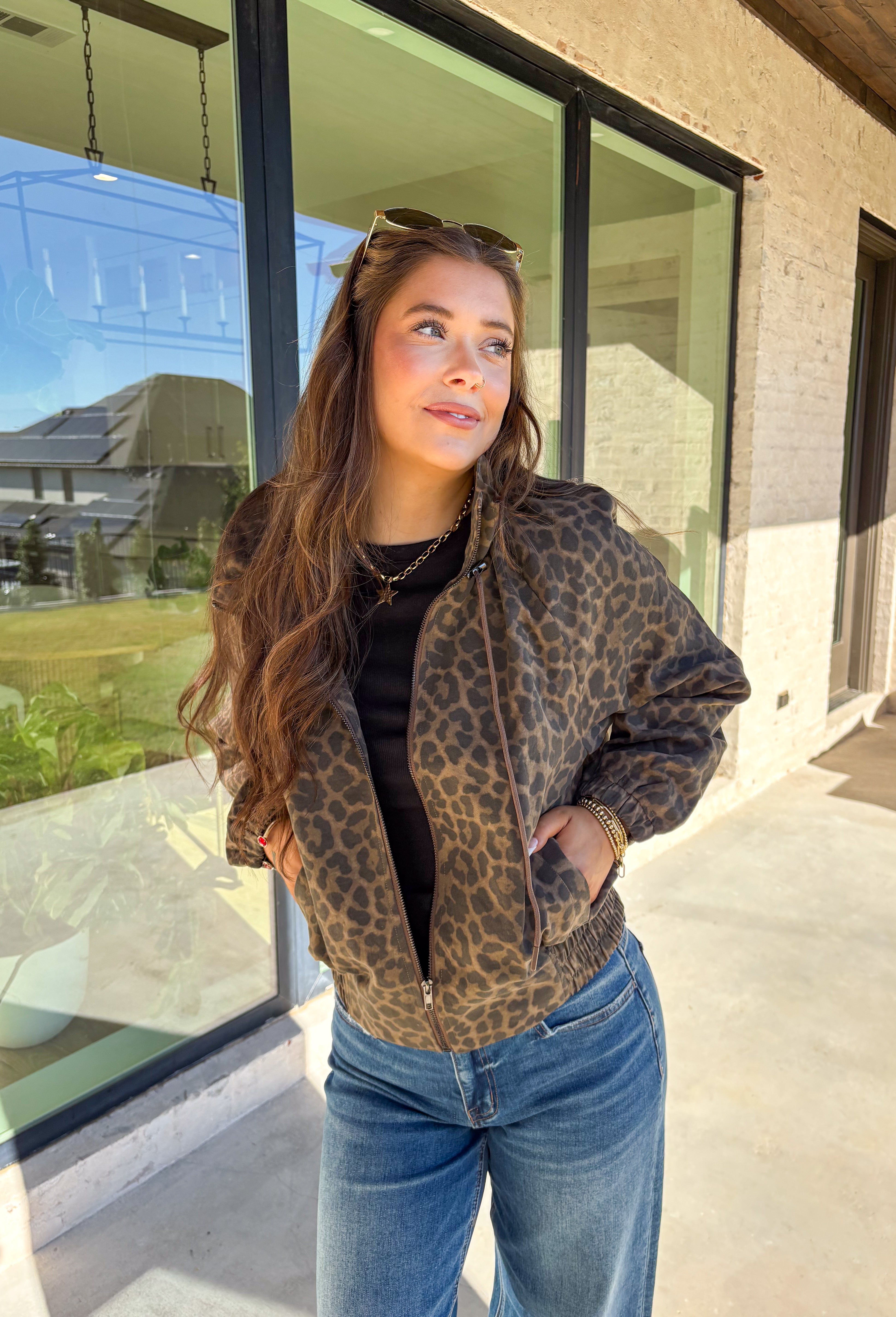 Bring the wild side to your fall layering with this leopard zip-up jacket! The ruffle neckline and tie-front detail add a playful twist to a classic print, while the elastic cuffs and hem keep it comfy and flattering. Toss it over your favorite tee and jeans for an effortless outfit that still makes a statement.