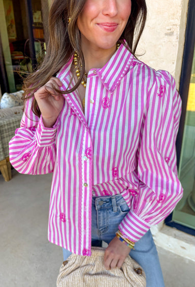 This pink and white striped button down is giving total springtime charm! With delicate embroidered pink paisley details sprinkled throughout, it’s the kind of top that feels classic at first glance… then you notice the pretty texture and it’s instantly a favorite. The collared neckline keeps it polished and easy to style, whether you’re heading to brunch, the office, or just want to look put-together for everyday plans. Lightweight and breathable, it’s a dreamy warm-weather staple you’ll reach for again an