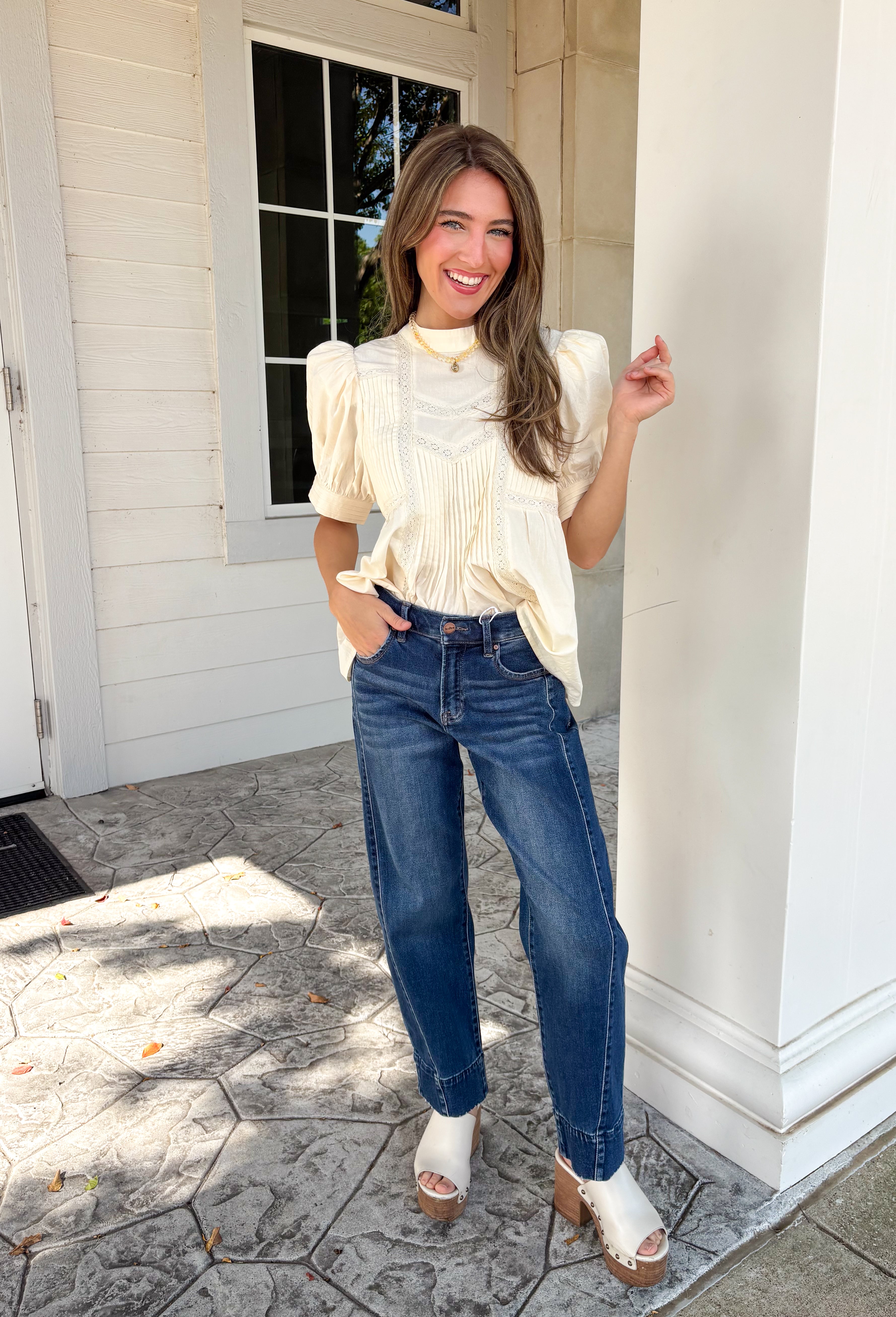 Soft, feminine, and effortlessly timeless, this beautiful ecru top is the kind of piece you'll treasure season after season! Crafted from breathable cotton, it features delicate lace detailing and chic pleating throughout for a look that's both romantic and refined. The puff sleeves add just the right amount of charm, while the keyhole button closure at the back provides a graceful finishing touch. 