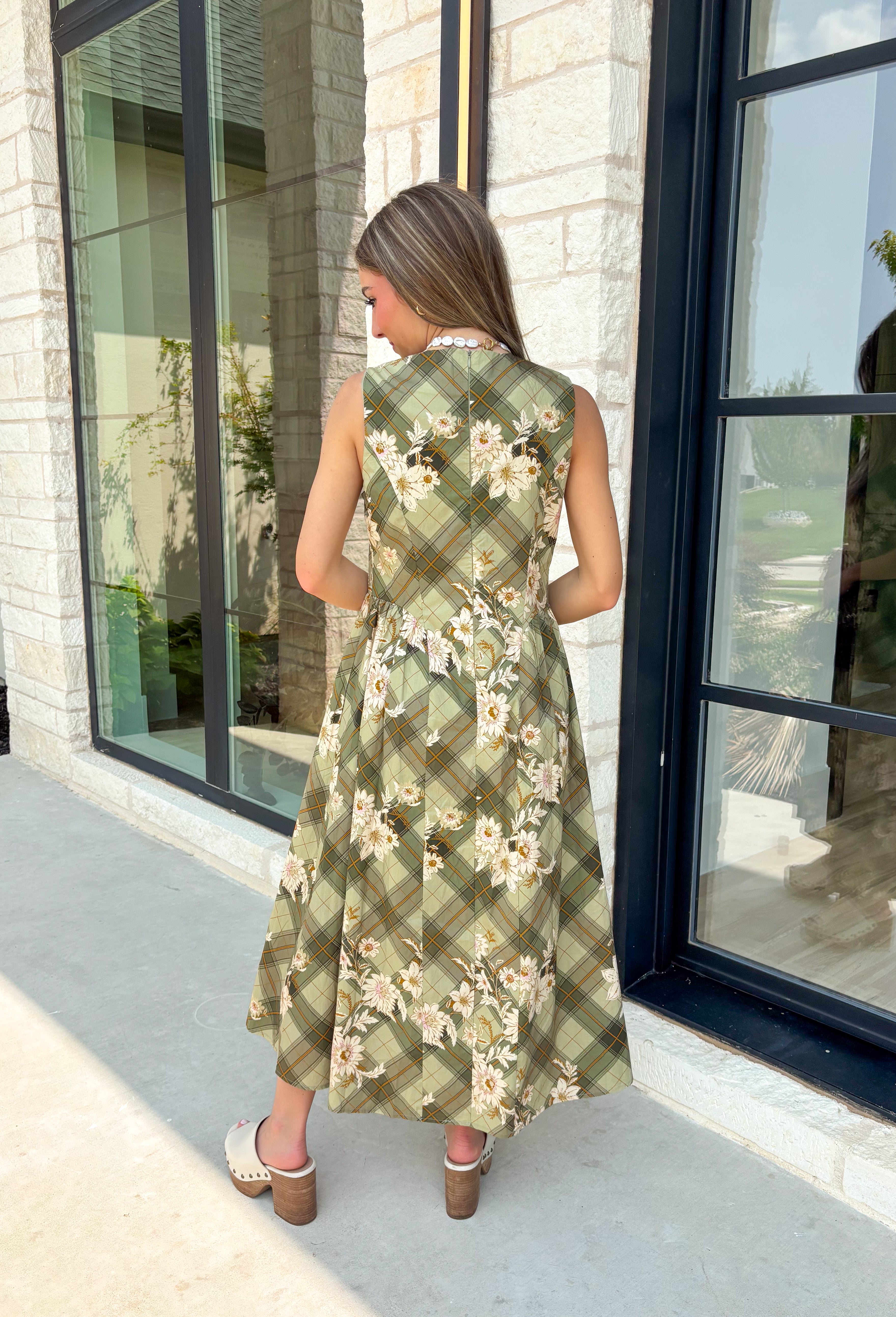 Classic plaid meets soft florals in this charming midi dress that's made for all your favorite fall occasions! Featuring an olive plaid backdrop with a neutral floral print, this cotton dress offers a unique blend of timeless patterns that feels effortlessly seasonal. The flattering v-neckline and sleeveless silhouette make it easy to wear on its own during warmer days or layered under a cardigan or denim jacket as the temperatures cool. 