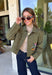 Make a statement everywhere you go with this stunning denim jacket from Veveret. Crafted in a rich olive denim, this standout layer features a breathtaking sheer embroidered floral design across the back, accented with shimmering sequins in shades of green, pink, orange, and brown. Coordinating floral sequin details on the front pockets tie the look together beautifully, while the classic collared neckline and button-front design keep it timeless. 