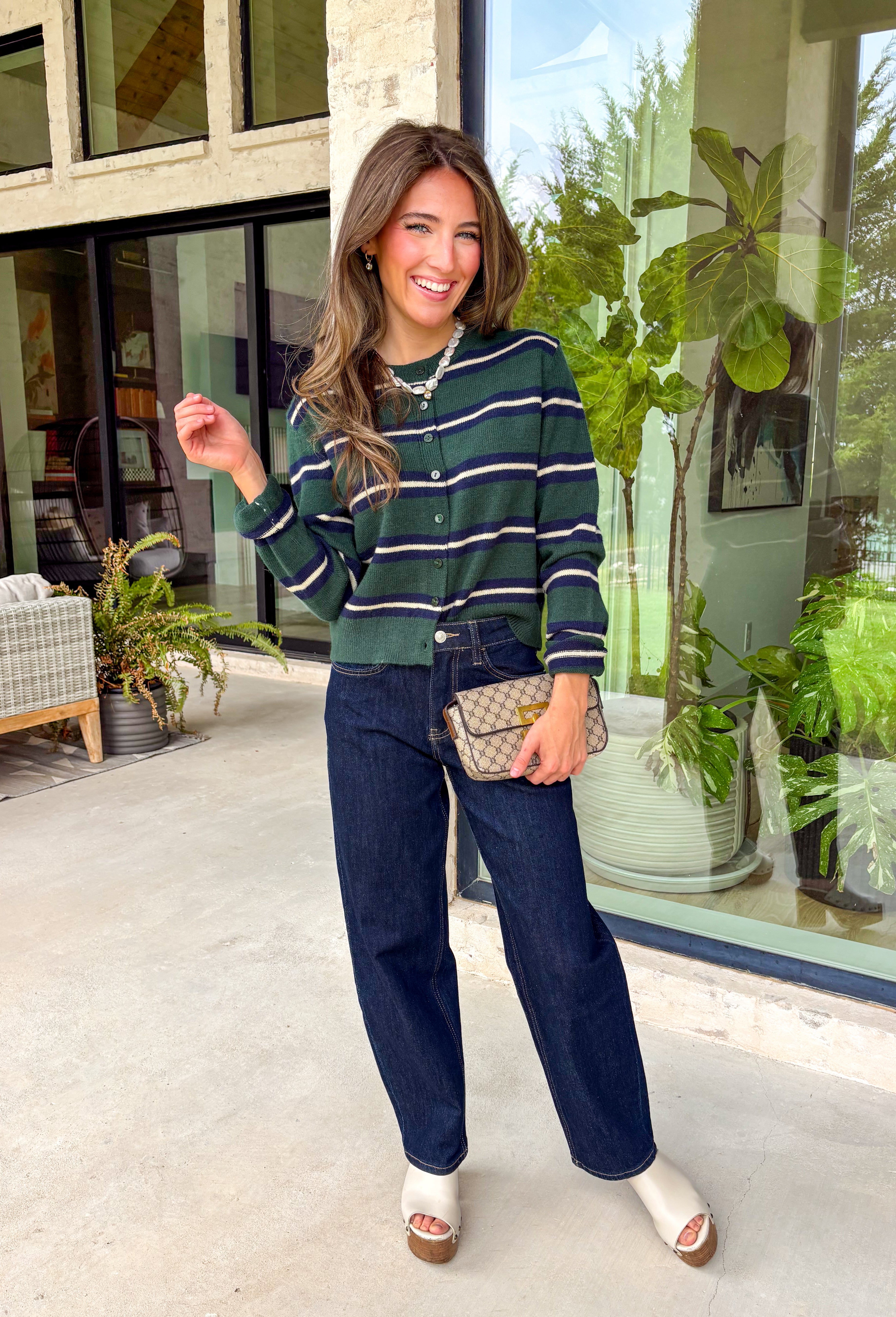 Nothing says cozy season quite like a classic striped cardigan! This hunter green knit features timeless navy blue and off white stripes, making it the perfect layering piece for all your fall adventures. Designed with a button-down front and an irresistibly soft feel, it's easy to wear open over your favorite basics or buttoned as a sweater for a polished look. 