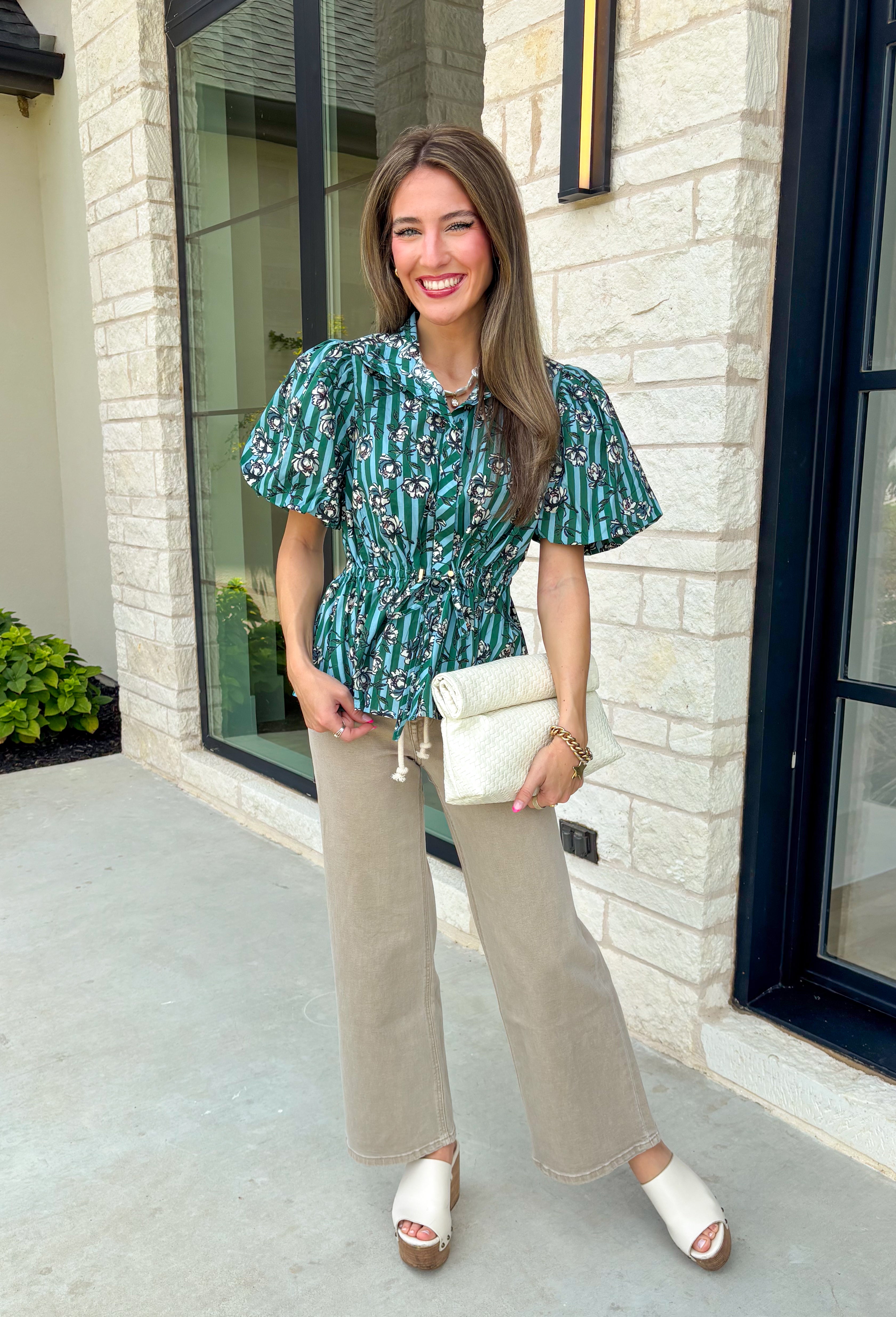Add a little charm to your everyday wardrobe with this beautifully detailed blouse that's full of fall-inspired style. Featuring hunter green and light blue stripes layered with a neutral floral print, this top offers a fresh take on two timeless patterns. The puff sleeves, button-front design, and elastic drawstring waist create a flattering silhouette that's both comfortable and polished. 