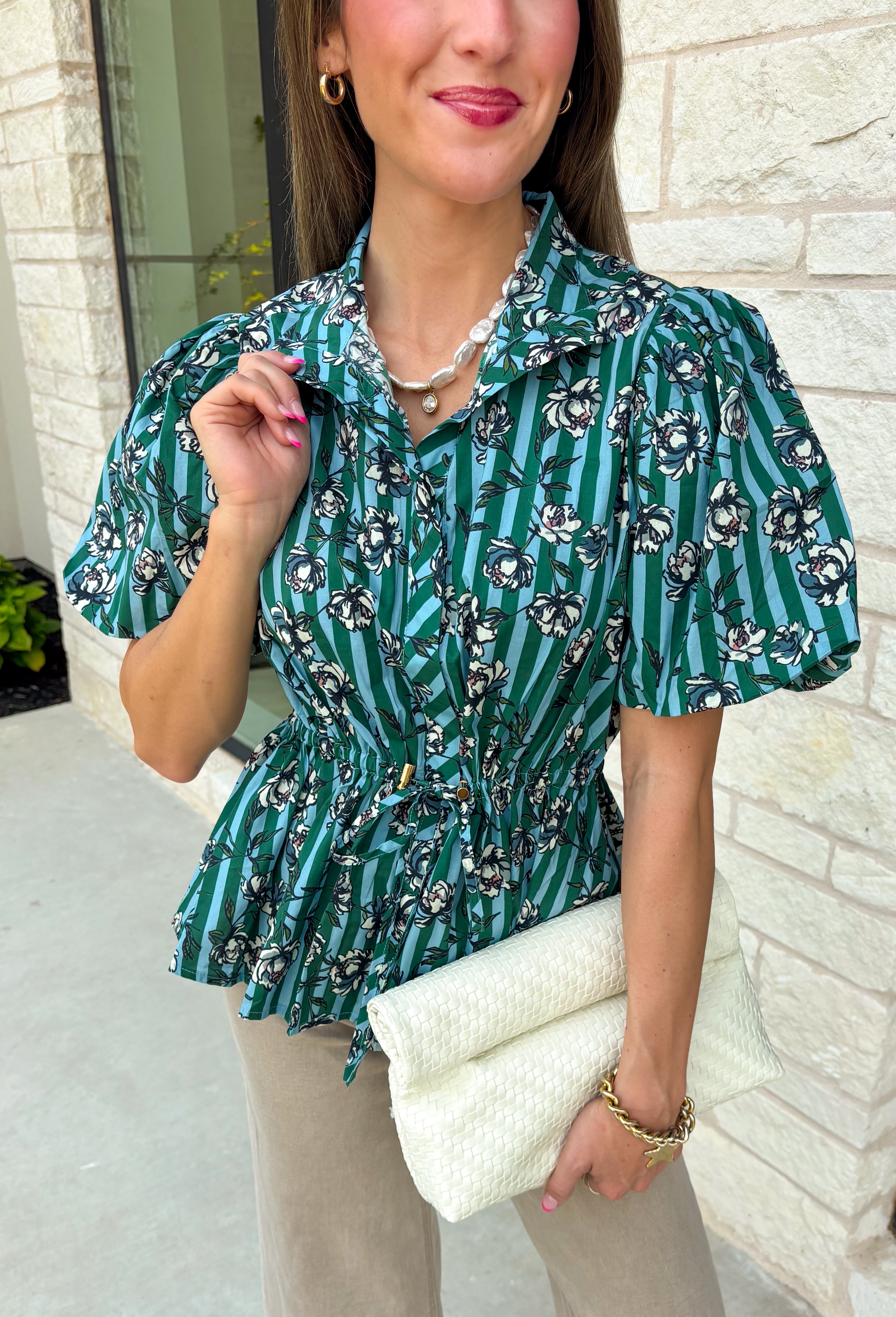 Add a little charm to your everyday wardrobe with this beautifully detailed blouse that's full of fall-inspired style. Featuring hunter green and light blue stripes layered with a neutral floral print, this top offers a fresh take on two timeless patterns. The puff sleeves, button-front design, and elastic drawstring waist create a flattering silhouette that's both comfortable and polished. 