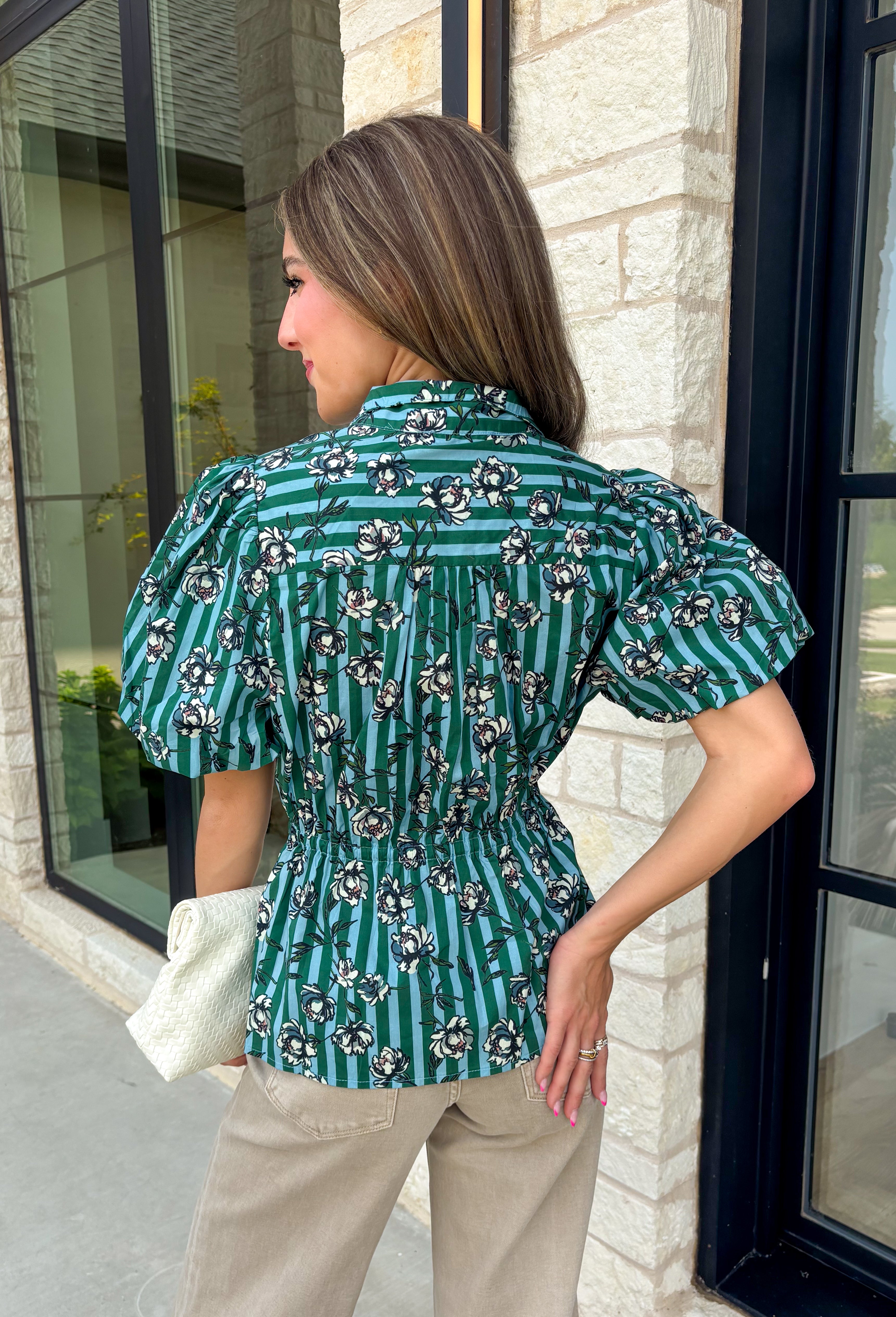 Add a little charm to your everyday wardrobe with this beautifully detailed blouse that's full of fall-inspired style. Featuring hunter green and light blue stripes layered with a neutral floral print, this top offers a fresh take on two timeless patterns. The puff sleeves, button-front design, and elastic drawstring waist create a flattering silhouette that's both comfortable and polished. 