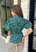 Add a little charm to your everyday wardrobe with this beautifully detailed blouse that's full of fall-inspired style. Featuring hunter green and light blue stripes layered with a neutral floral print, this top offers a fresh take on two timeless patterns. The puff sleeves, button-front design, and elastic drawstring waist create a flattering silhouette that's both comfortable and polished. 