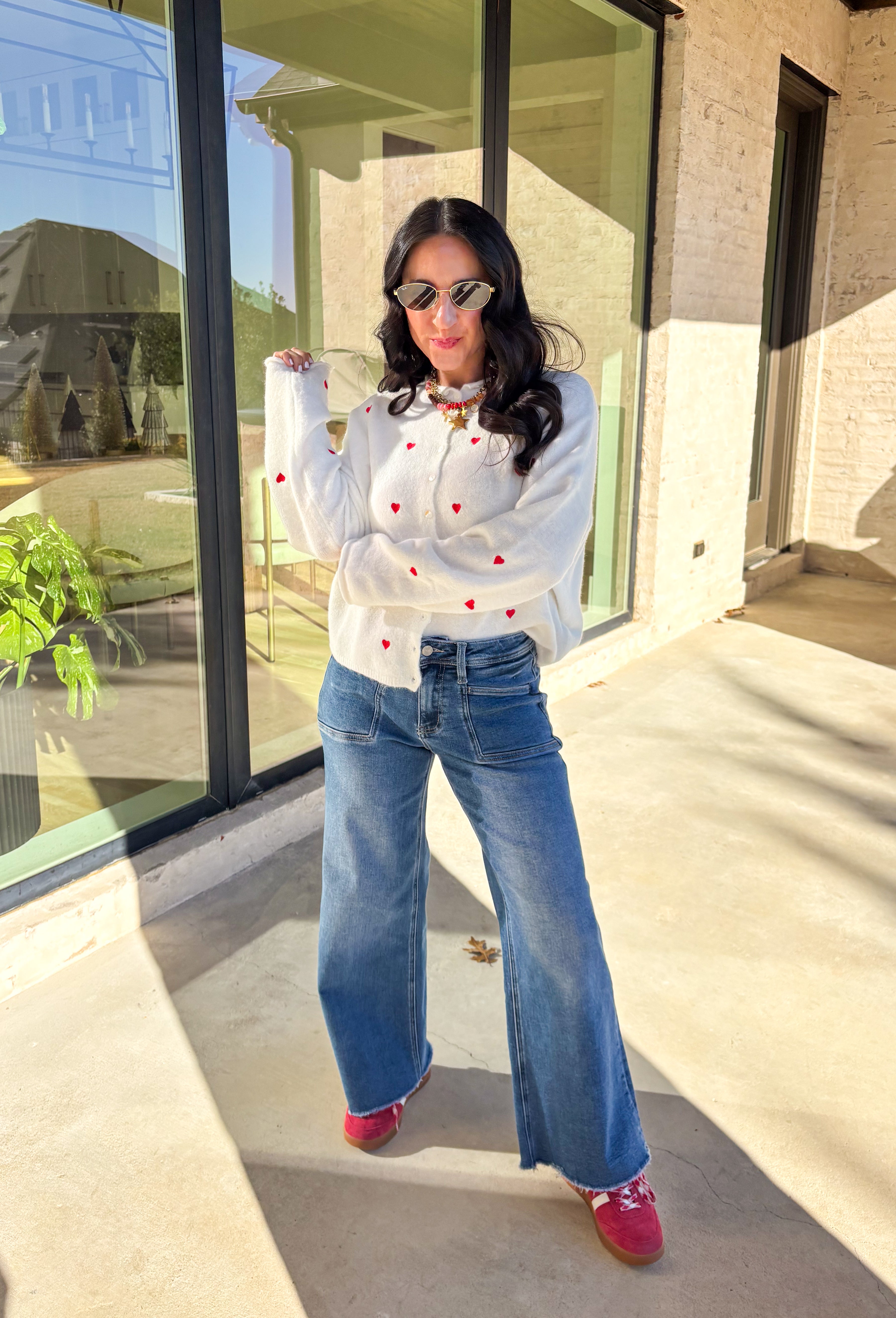 Add a little love to your look with this darling white button-down cardigan by Things Between. Featuring red embroidered hearts throughout and a scalloped trim along the front, this cozy knit is the perfect mix of cute and classic. Soft, feminine, and full of charm, it’s the perfect layer for Valentine’s Day and beyond.