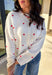 Add a little love to your look with this darling white button-down cardigan by Things Between. Featuring red embroidered hearts throughout and a scalloped trim along the front, this cozy knit is the perfect mix of cute and classic. Soft, feminine, and full of charm, it’s the perfect layer for Valentine’s Day and beyond.