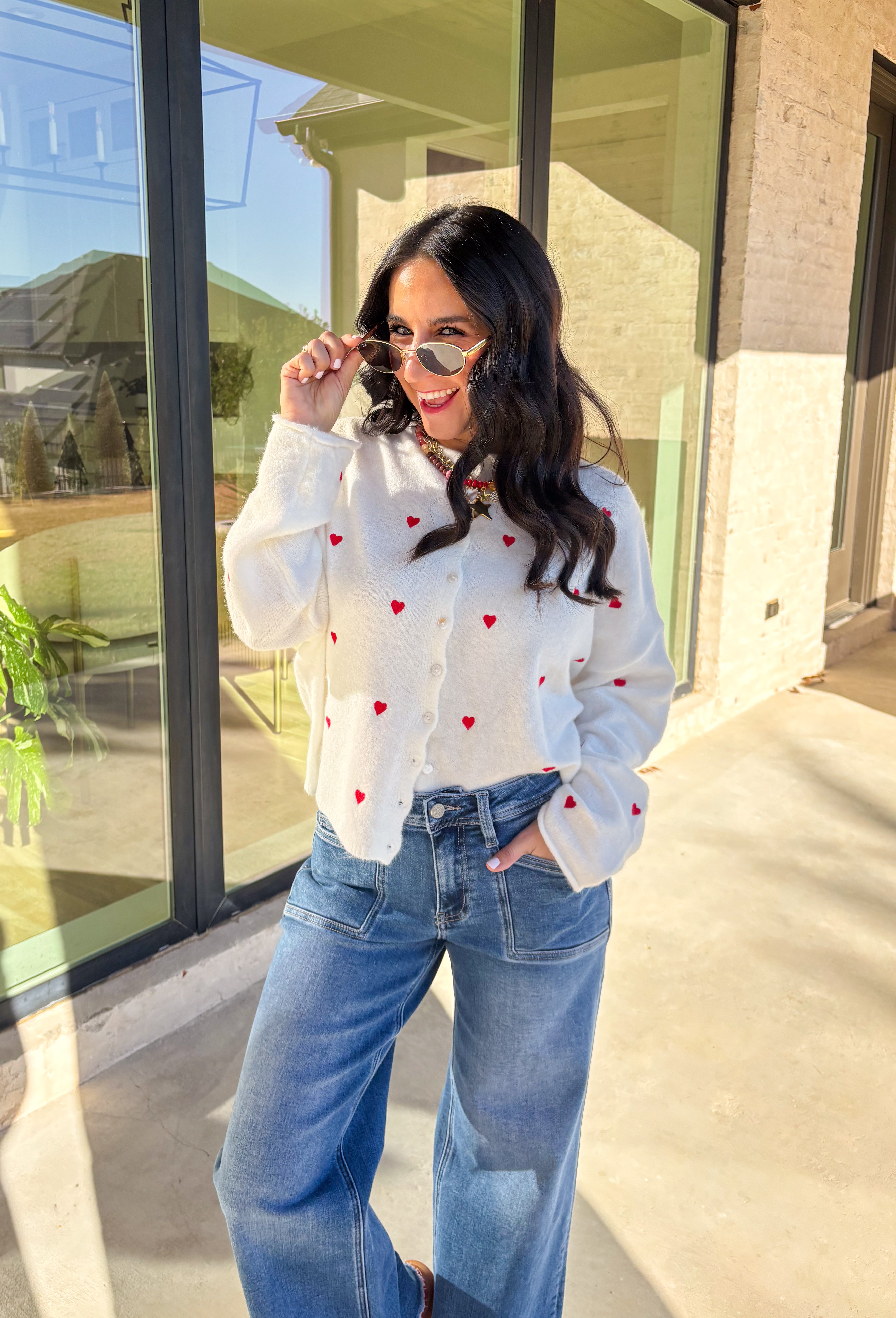 Add a little love to your look with this darling white button-down cardigan by Things Between. Featuring red embroidered hearts throughout and a scalloped trim along the front, this cozy knit is the perfect mix of cute and classic. Soft, feminine, and full of charm, it’s the perfect layer for Valentine’s Day and beyond.