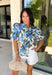 Fresh, feminine, and perfect for spring, this off-white button-down top by Entro is an easy standout. Featuring a blue floral print with pops of hunter green, it gives you the prettiest mix of color while still feeling classic and wearable. The ruffle neckline adds a sweet, polished touch, and puff sleeves bring that soft, feminine silhouette we love. Made from breathable cotton, this top is perfect for sunny days, brunch plans, and effortless spring outfits.