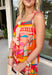 This orange sleeveless midi dress is pure sunshine in outfit form. Covered in a vibrant tropical print with pops of yellow, blue, green, and red, it instantly brings bold, vacation-ready energy to your wardrobe. The adjustable tie straps add a sweet, feminine touch while allowing for a customizable fit. Designed with a flowy tiered skirt and fully lined for easy wear, this dress is made for warm days, beach getaways, and sunny celebrations.