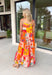 This orange sleeveless midi dress is pure sunshine in outfit form. Covered in a vibrant tropical print with pops of yellow, blue, green, and red, it instantly brings bold, vacation-ready energy to your wardrobe. The adjustable tie straps add a sweet, feminine touch while allowing for a customizable fit. Designed with a flowy tiered skirt and fully lined for easy wear, this dress is made for warm days, beach getaways, and sunny celebrations.