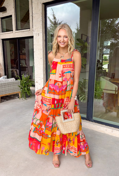 This orange sleeveless midi dress is pure sunshine in outfit form. Covered in a vibrant tropical print with pops of yellow, blue, green, and red, it instantly brings bold, vacation-ready energy to your wardrobe. The adjustable tie straps add a sweet, feminine touch while allowing for a customizable fit. Designed with a flowy tiered skirt and fully lined for easy wear, this dress is made for warm days, beach getaways, and sunny celebrations.