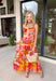 This orange sleeveless midi dress is pure sunshine in outfit form. Covered in a vibrant tropical print with pops of yellow, blue, green, and red, it instantly brings bold, vacation-ready energy to your wardrobe. The adjustable tie straps add a sweet, feminine touch while allowing for a customizable fit. Designed with a flowy tiered skirt and fully lined for easy wear, this dress is made for warm days, beach getaways, and sunny celebrations.