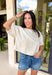 Understated and effortlessly pretty, this khaki short sleeve top is all about the details. The monochromatic floral embroidery adds soft texture without overwhelming the look, giving it that elevated, timeless feel you’ll reach for again and again. Designed with elastic cuff sleeves for a subtle puff effect and finished with a delicate keyhole closure in the back, this top blends feminine touches with everyday ease. The breathable linen blend keeps it lightweight and comfortable.