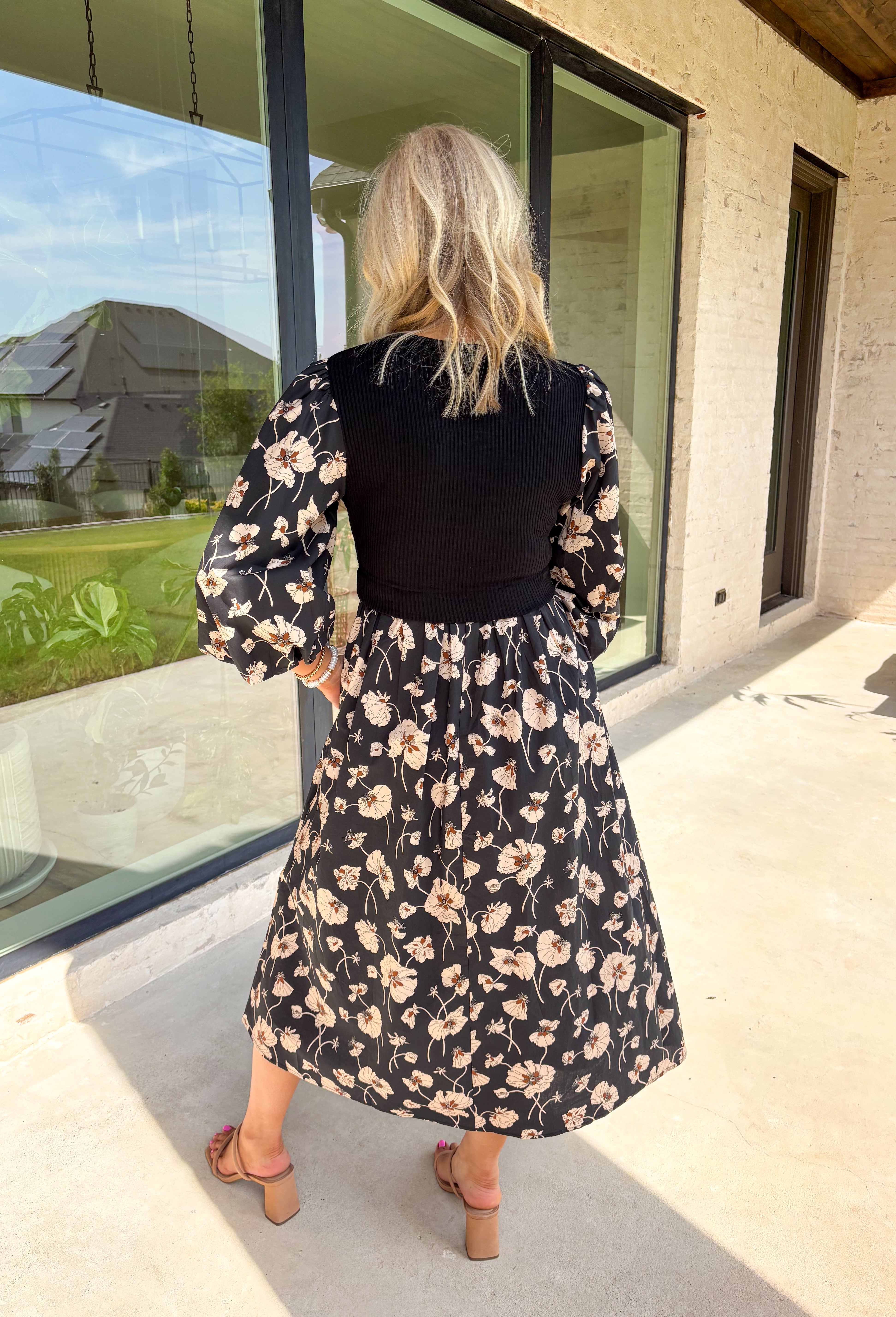 All the layered style, none of the layering fuss—this black midi dress makes autumn dressing a breeze. With a soft neutral floral print and solid black ribbed front panel, it creates that effortless "sweater over dress" vibe without adding bulk. The balloon sleeves and elastic cuffs give it a romantic, flowy feel, while the midi length keeps it versatile for boots or flats. Comfortable, polished, and totally ready for cooler days, this dress is the perfect blend of cozy and put-together.