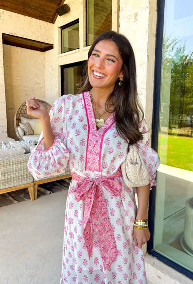 This white floral midi dress by Entro is giving the sweetest spring energy! Covered in a pretty pink floral print, it’s fresh, feminine, and perfect for everything from brunch dates to baby showers. The pink contrast trim adds such a fun pop and gives the dress that extra polished look, while the self-tie detail at the front waist lets you cinch it in for a flattering fit.