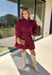Rich burgundy makes this dress from Entro an easy favorite for all the plans filling up your fall calendar. The stand collar and split neckline create a classic look, while the button-front closure adds a pretty finishing detail. Long balloon sleeves bring soft volume to the silhouette and are finished with button cuffs for a more tailored touch. A removable self-tie belt lets you define the waist or switch up the look, while the tiered skirt adds movement and shape. 