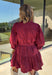 Rich burgundy makes this dress from Entro an easy favorite for all the plans filling up your fall calendar. The stand collar and split neckline create a classic look, while the button-front closure adds a pretty finishing detail. Long balloon sleeves bring soft volume to the silhouette and are finished with button cuffs for a more tailored touch. A removable self-tie belt lets you define the waist or switch up the look, while the tiered skirt adds movement and shape. 